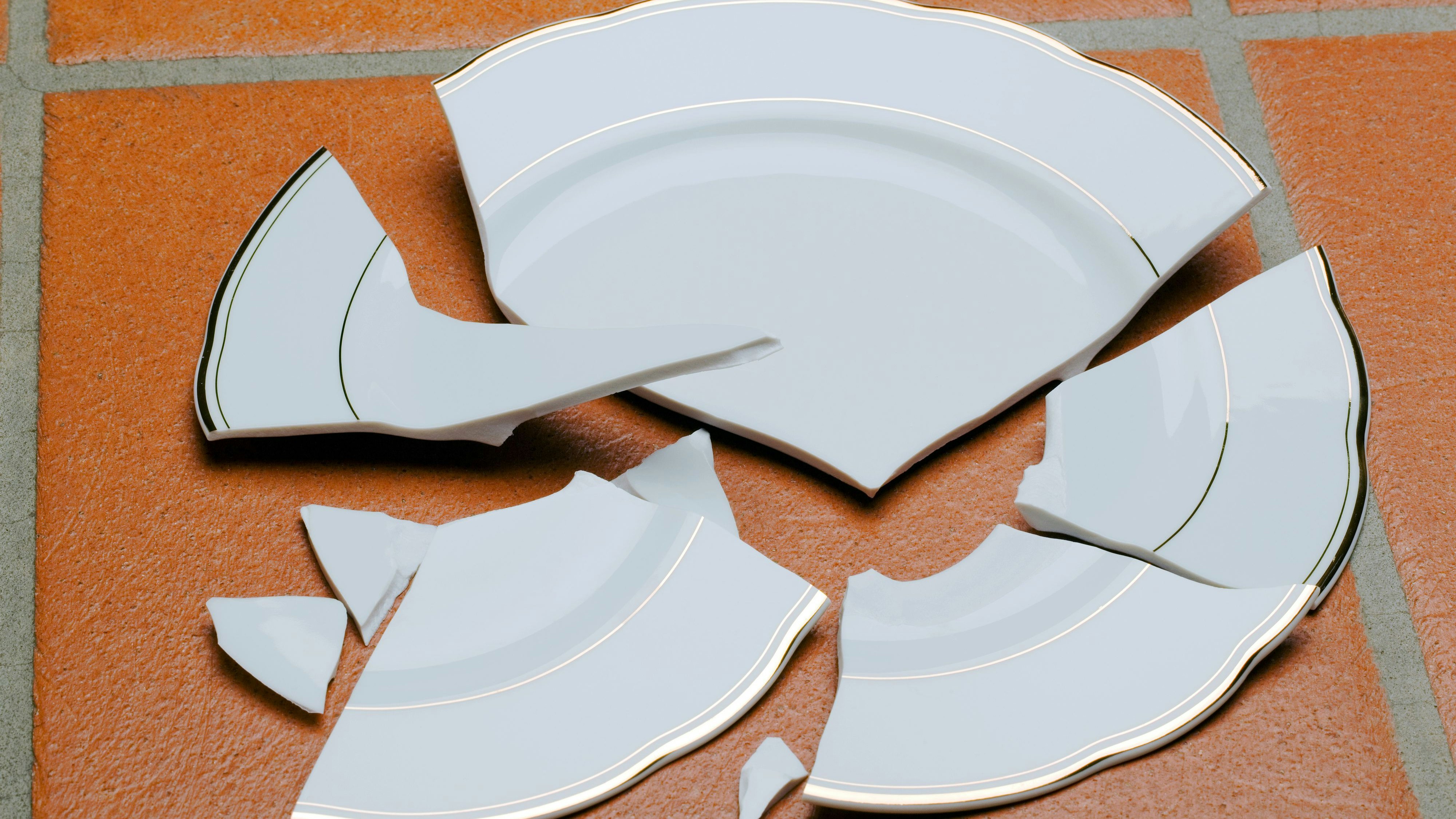 Ein zerbrochener Teller liegt auf dem Boden in der Küche.