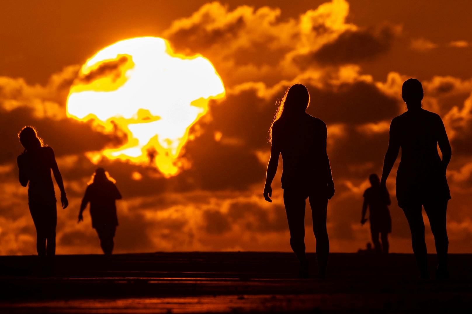 Strandbesucher bei Sonnenuntergang in South Carolina. Auch die USA waren im Juli von einer massiven Hitzewelle betroffen.