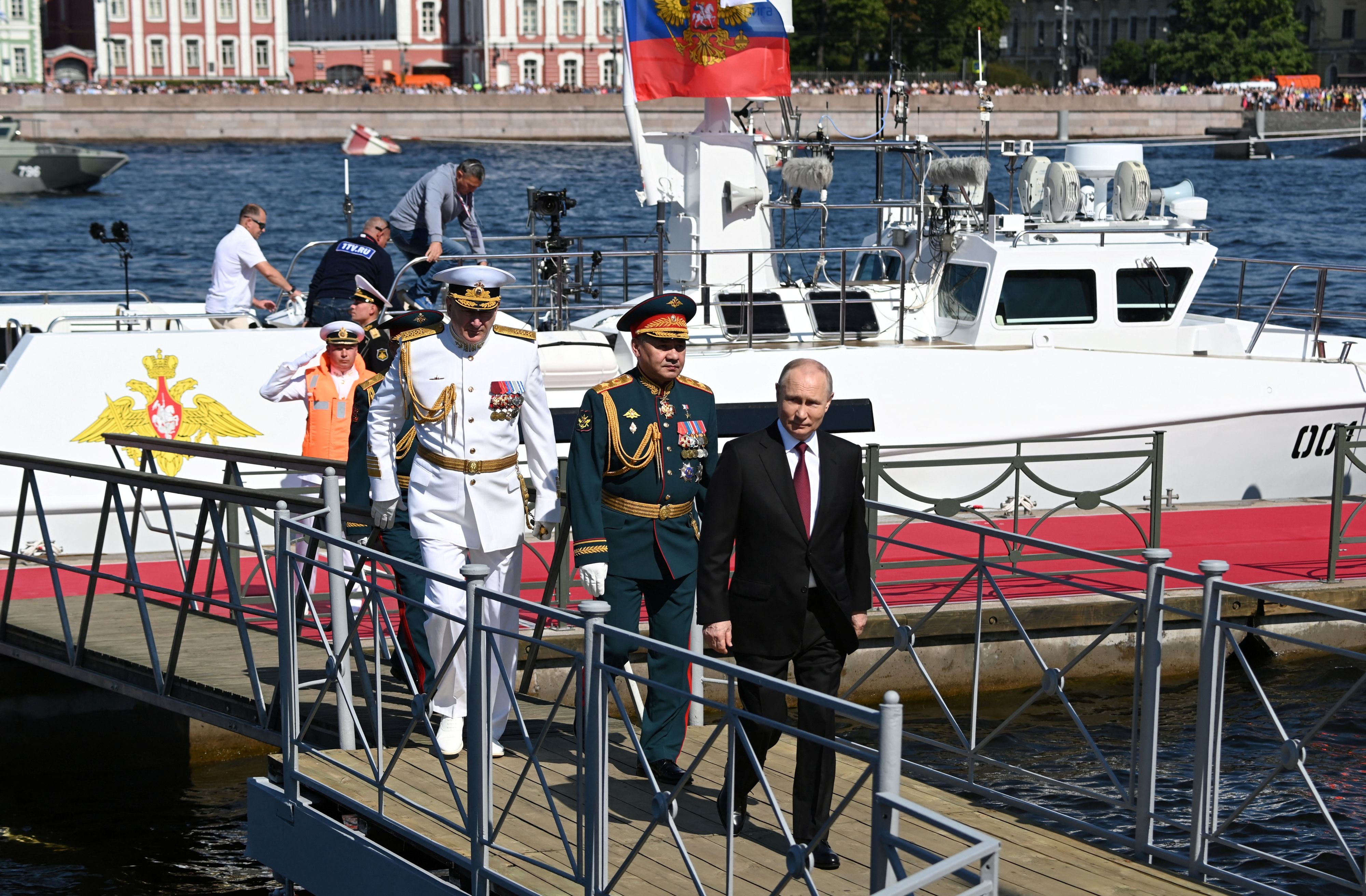 Der russische Präsident Wladimir Putin (vorne), sein Verteidigungsminister Sergej Schoigu (in grün) sowie Admiral Admiral Nikolai Jewmenow (in weiß) bei der Marineparade in St. Petersburg am Sonntag (30.07.2023).
