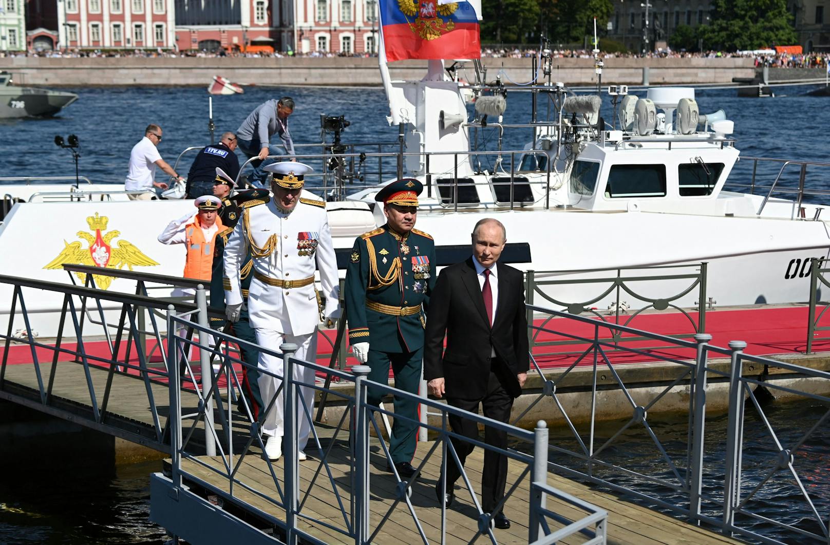 Der russische Präsident Wladimir Putin (vorne), sein Verteidigungsminister Sergej Schoigu (in grün) sowie Admiral Admiral Nikolai Jewmenow (in weiß) bei der Marineparade in St. Petersburg am Sonntag (30.07.2023).