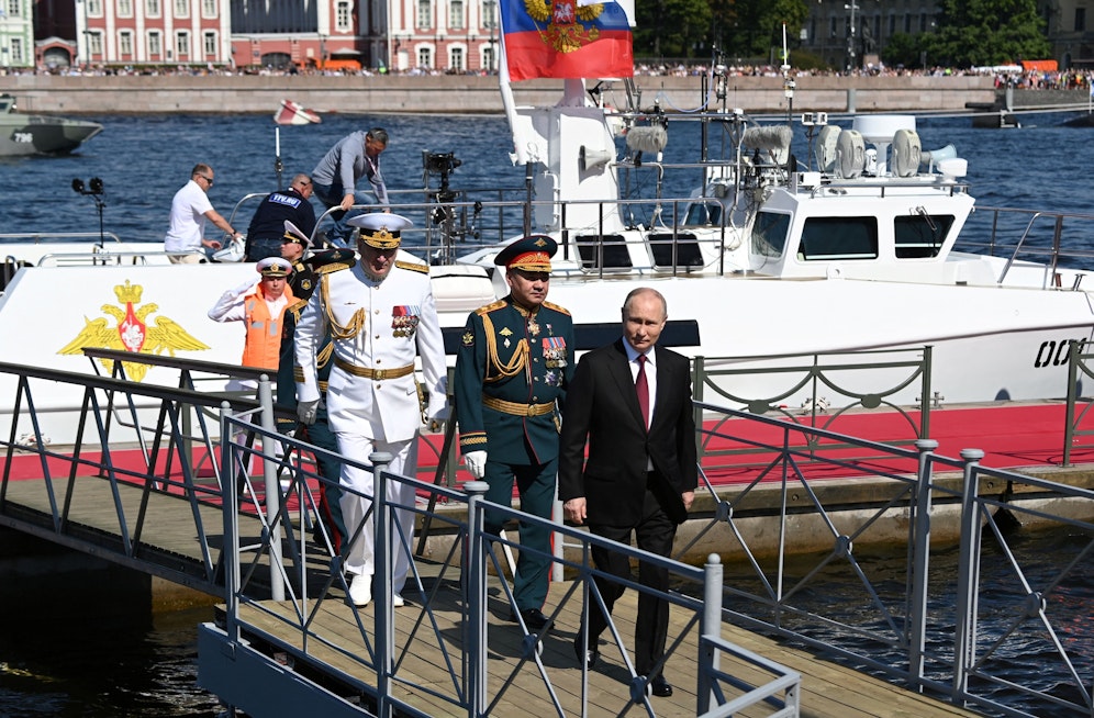 Der russische Präsident Wladimir Putin (vorne), sein Verteidigungsminister Sergej Schoigu (in grün) sowie Admiral Admiral Nikolai Jewmenow (in weiß) bei der Marineparade in St. Petersburg am Sonntag (30.07.2023).