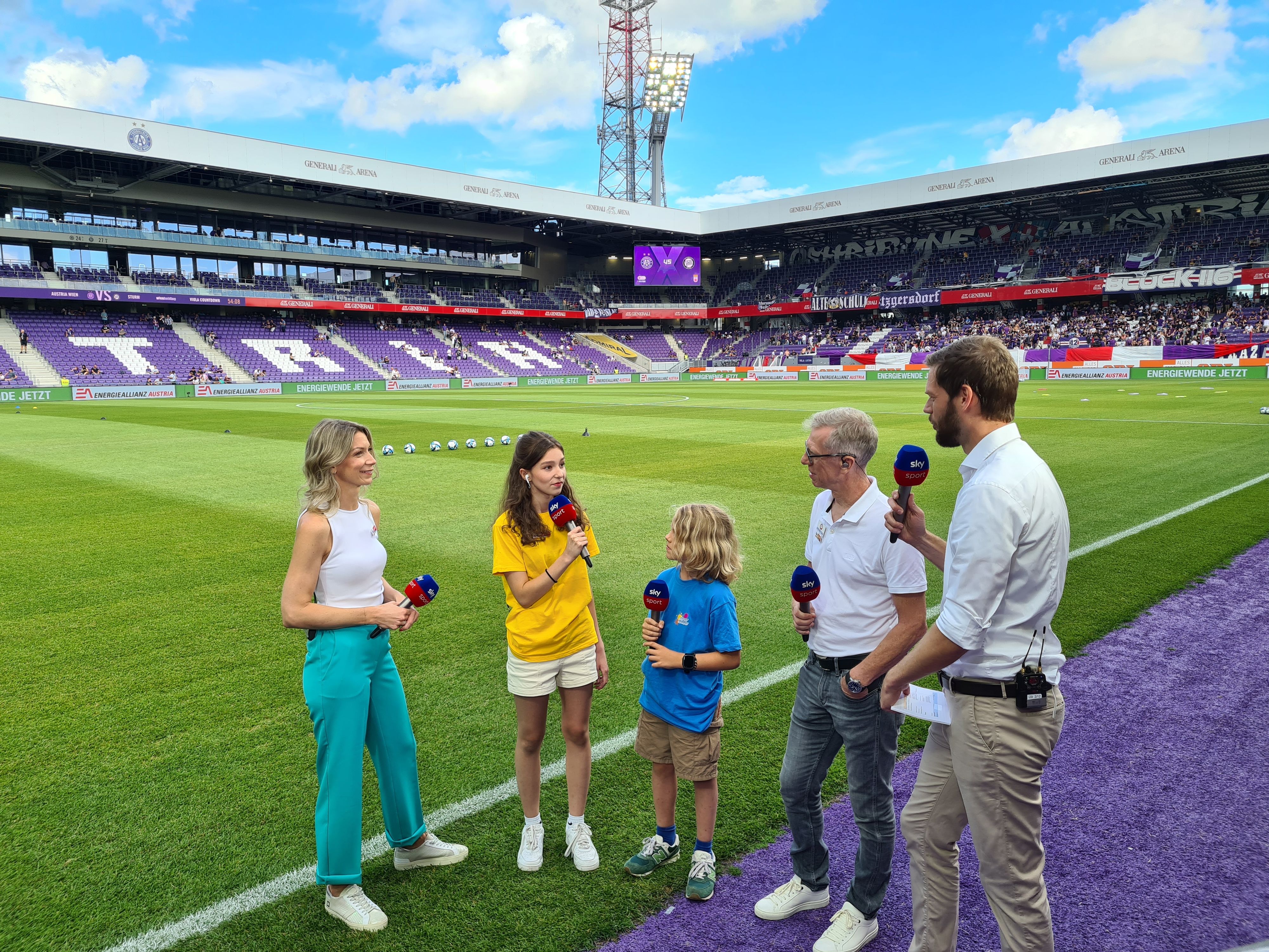 Die Kinderreporter von Sky im Einsatz – mit dabei: die Moderatoren Constanze Weiss (l.) und Johannes Brandl (r.) sowie Experte Peter Stöger (zweiter von rechts).