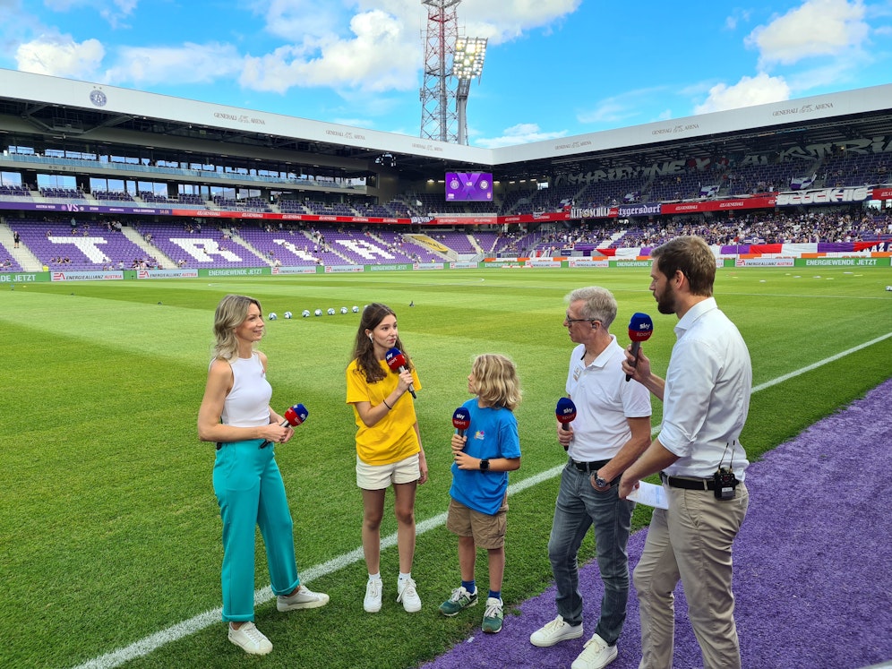 Die Kinderreporter von Sky im Einsatz – mit dabei: die Moderatoren Constanze Weiss (l.) und Johannes Brandl (r.) sowie Experte Peter Stöger (zweiter von rechts).