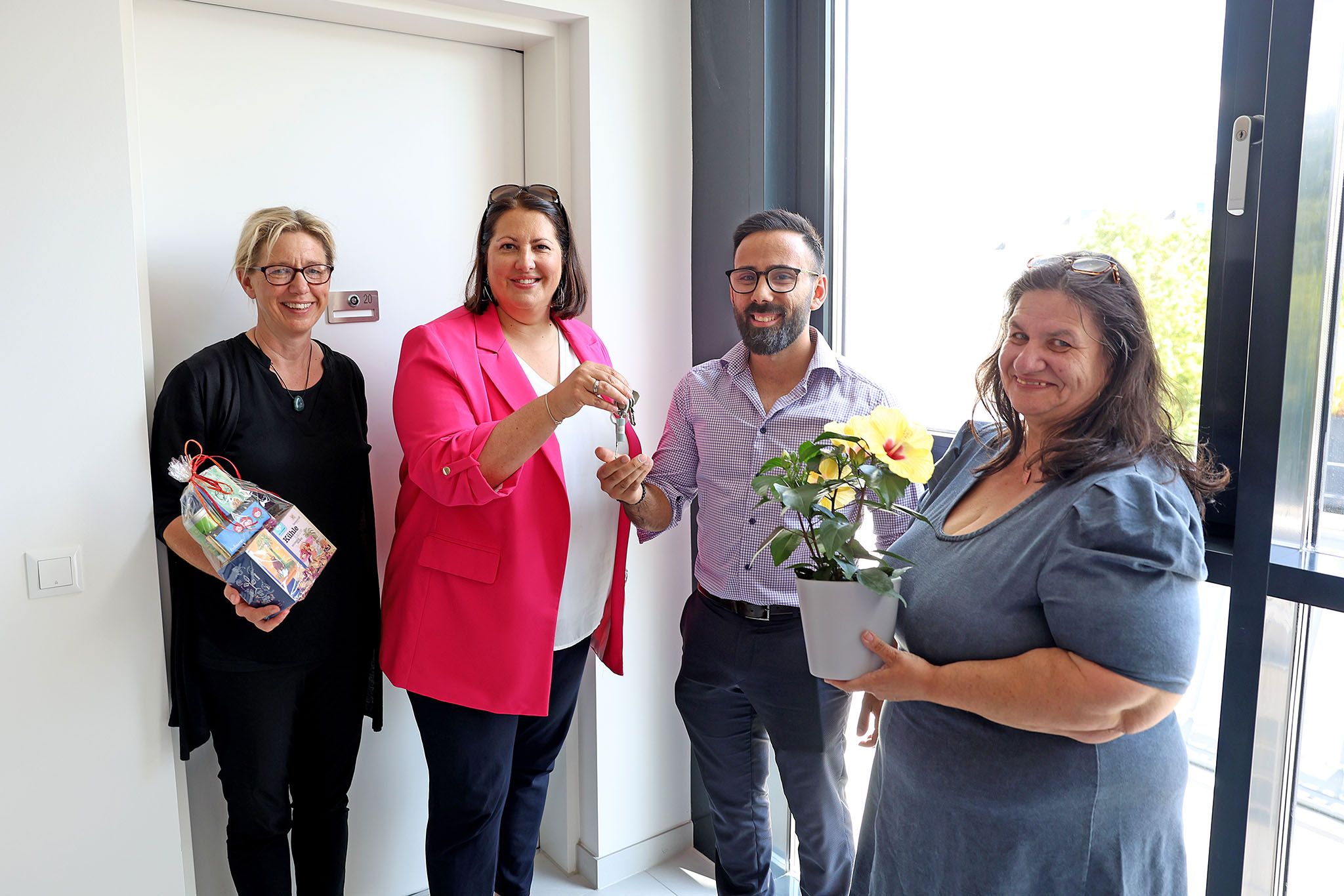 Wiener Wohnen Direktorin Karin Ramser, Wohnbaustadträtin Kathrin Gaál und Bezirksvorsteher-Stellvertreterin Karin Eichler übergeben den SChlüssel an einen der ersten Mieter im neuen Gemeindebau