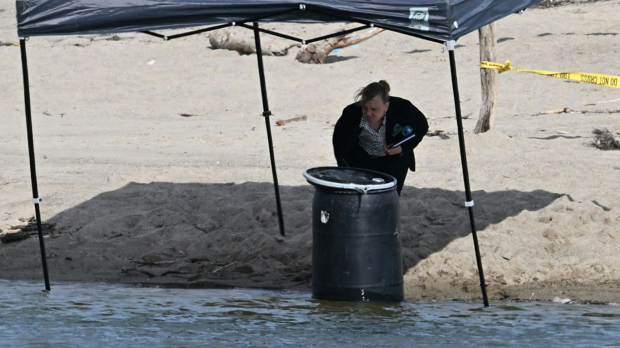 Download von www.picturedesk.com am 01.08.2023 (14:47).  An official stands next to a barrel where a body was discovered in Malibu Lagoon State Beach, California on July 31, 2023. A body stuffed in a barrel was discovered July 31, 2023 on Malibu Beach, a swanky Californian hotspot beloved by the rich and famous, police said. Reports said the man's corpse was crammed into a 55-gallon drum when it was discovered by maintenance workers. (Photo by Robyn Beck / AFP) - 20230731_PD7151 - Rechteinfo: Rights Managed (RM) Nur für redaktionelle Nutzung! Werbliche Nutzung erfordert Freigabe: bitte schicken Sie uns eine Anfrage.