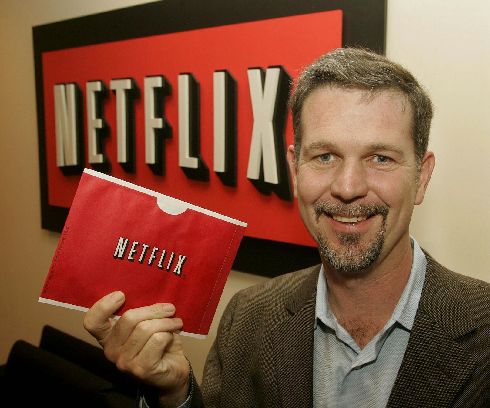 Reed Hastings, einer der Gründer von Netflix, hält in seiner Hand einen der roten Netflix-Umschläge, mit denen die Filme zu den Kunden verschickt wurden.