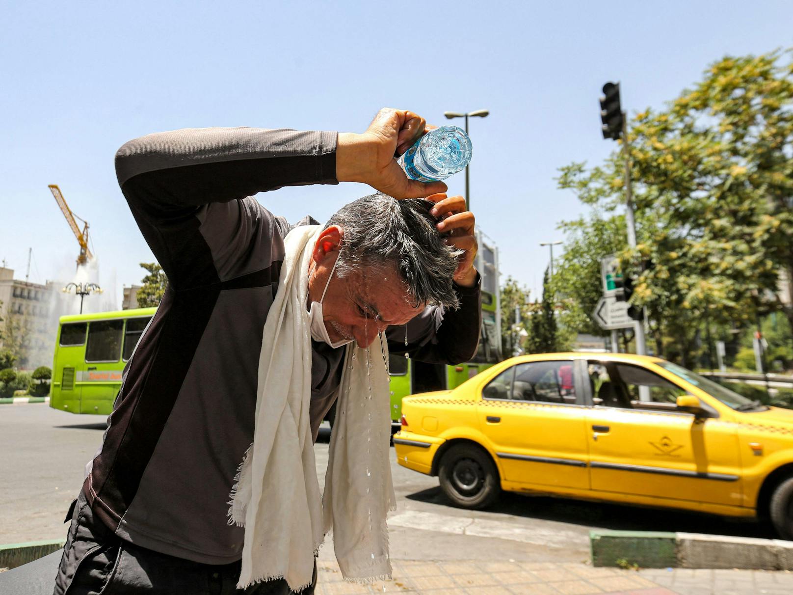 Teheran: Iranischer Taxifahrer kühlt sich mit Wasser ab.