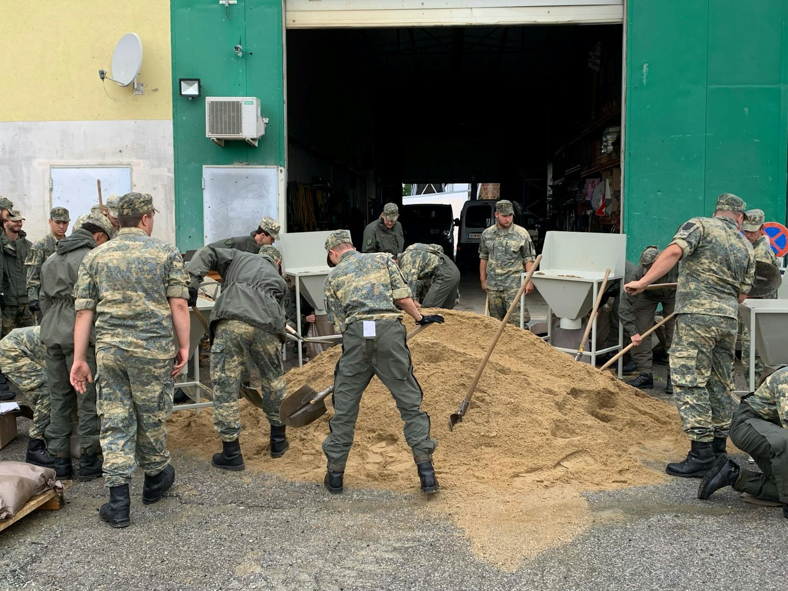 Soldaten der Güssinger Kaserne beim Befüllen von Sandsäcken im Assistenzeinsatz zur Hochwasserbekämpfung am 5. August 2023.