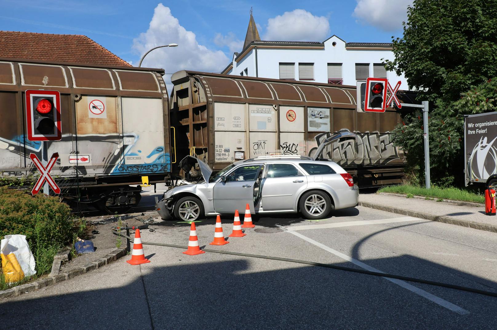 Auto auf Bahnübergang von Güterzug erfasst
