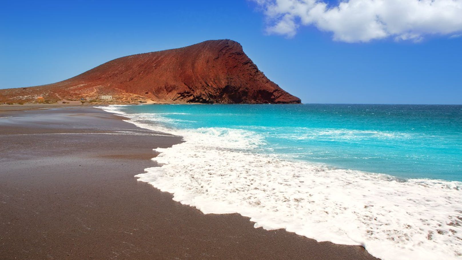 <strong>Playa La Tejita, Teneriffa, Spanien</strong>: Im westlichen Abschnitt des Strandes hinter einem Felsen versteckt sich an der Playa La Tejita eine schöne Bucht für FKK-Fans. Der feine, dunkle Sand und das türkisblaue Wasser vor ursprünglicher Natur bieten eine hervorragende Kulisse, um sich nahtlos bräunen zu lassen. Aufgrund der Lage kann es am Strand teils sehr windig werden, weshalb sich ein Besuch am Vormittag empfiehlt.