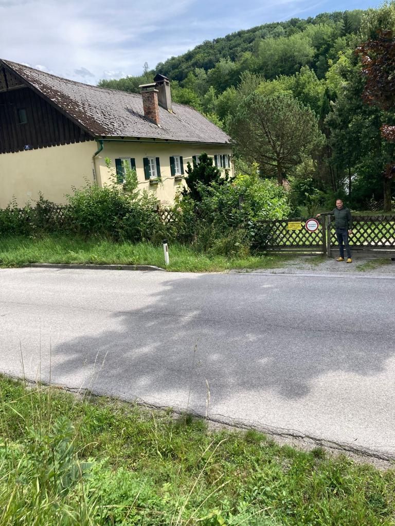 Stefan H. vor dem Weg, der mit einem Tor versperrt ist.
