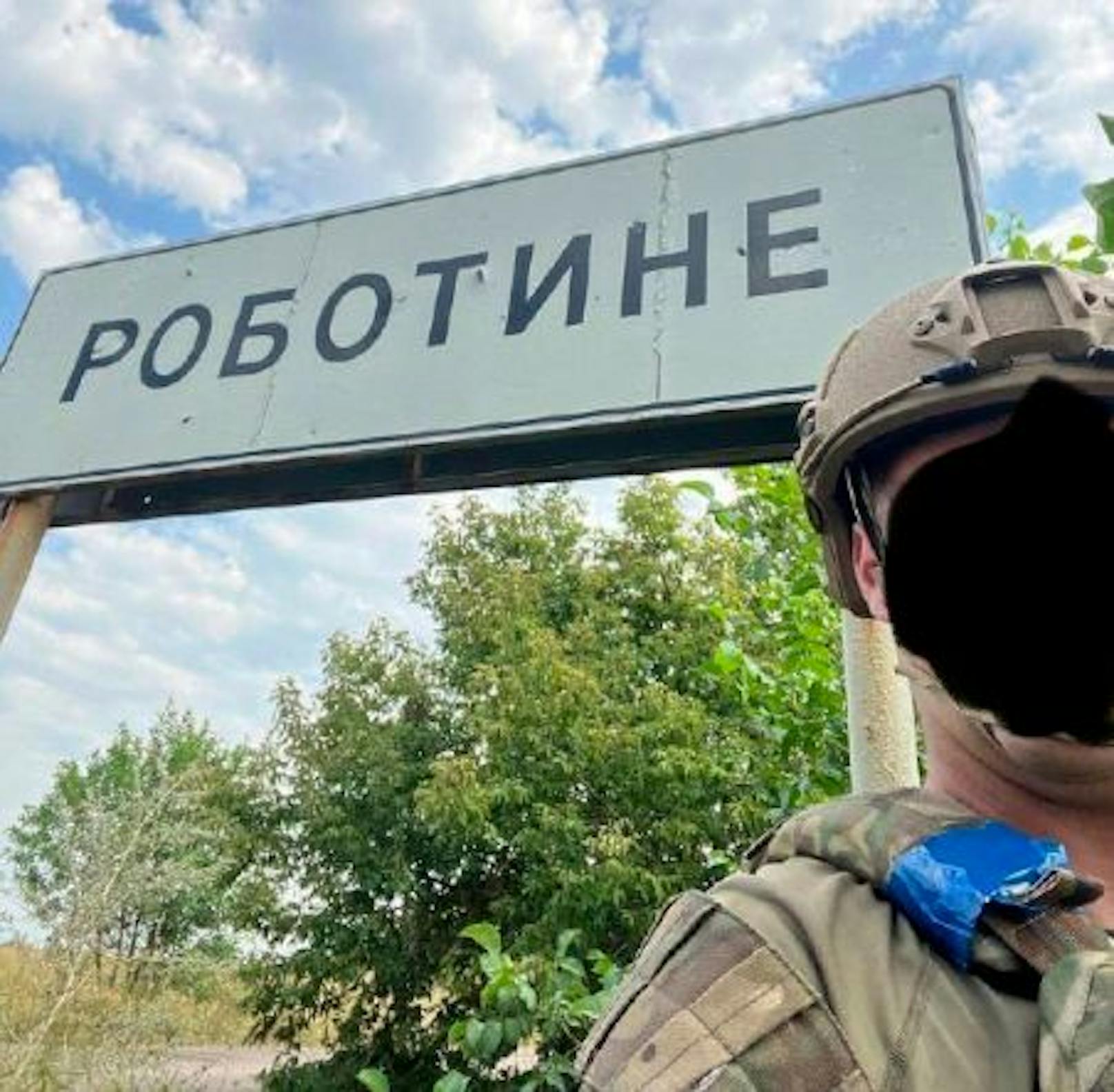 Ein ukrainischer Soldat vor dem Ortsschild von Robotyne im Oblast Saporischschja.