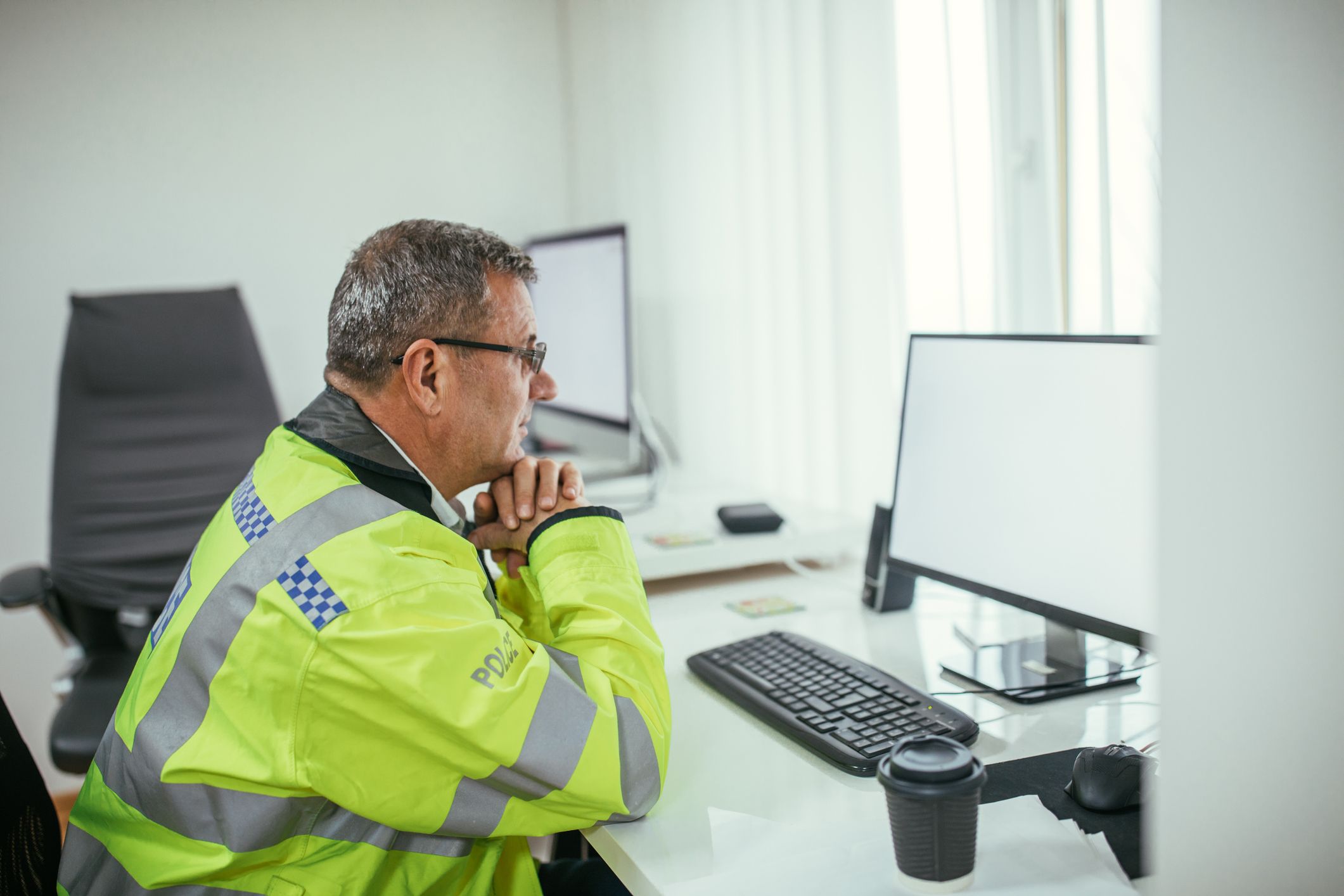 Britischer Polizist vor einem Computer