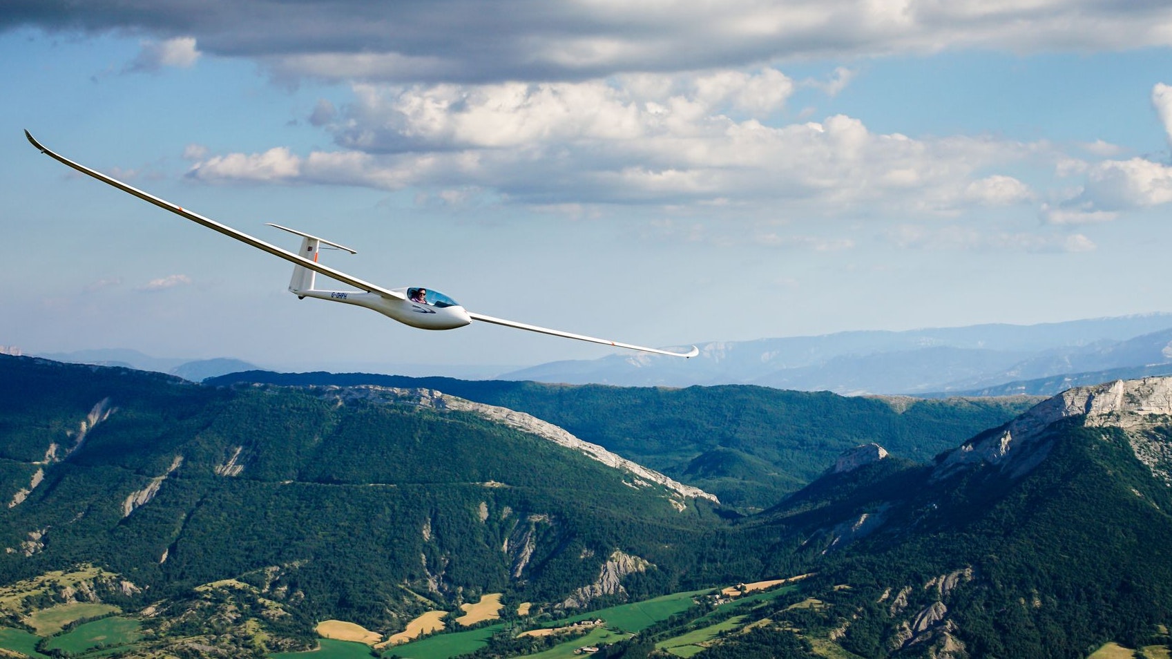 Glider flies under clouds