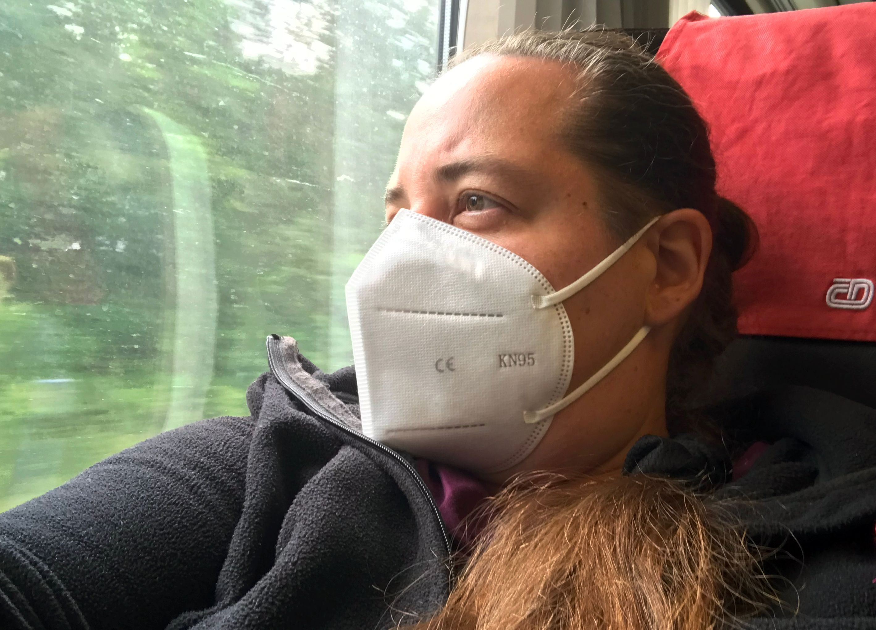 Download von www.picturedesk.com am 23.08.2023 (13:47).  16.07.2022, Berlin, Deutschland, Frau mit FFP2-Maske schaut bei einer Zugfahrt aus dem Fenster. 00S220716D550CARO.JPG [MODEL RELEASE: NO, PROPERTY RELEASE: NO (c) caro images / Frank Sorge - 20220716_PD21460 - Rechteinfo: Rights Managed (RM)