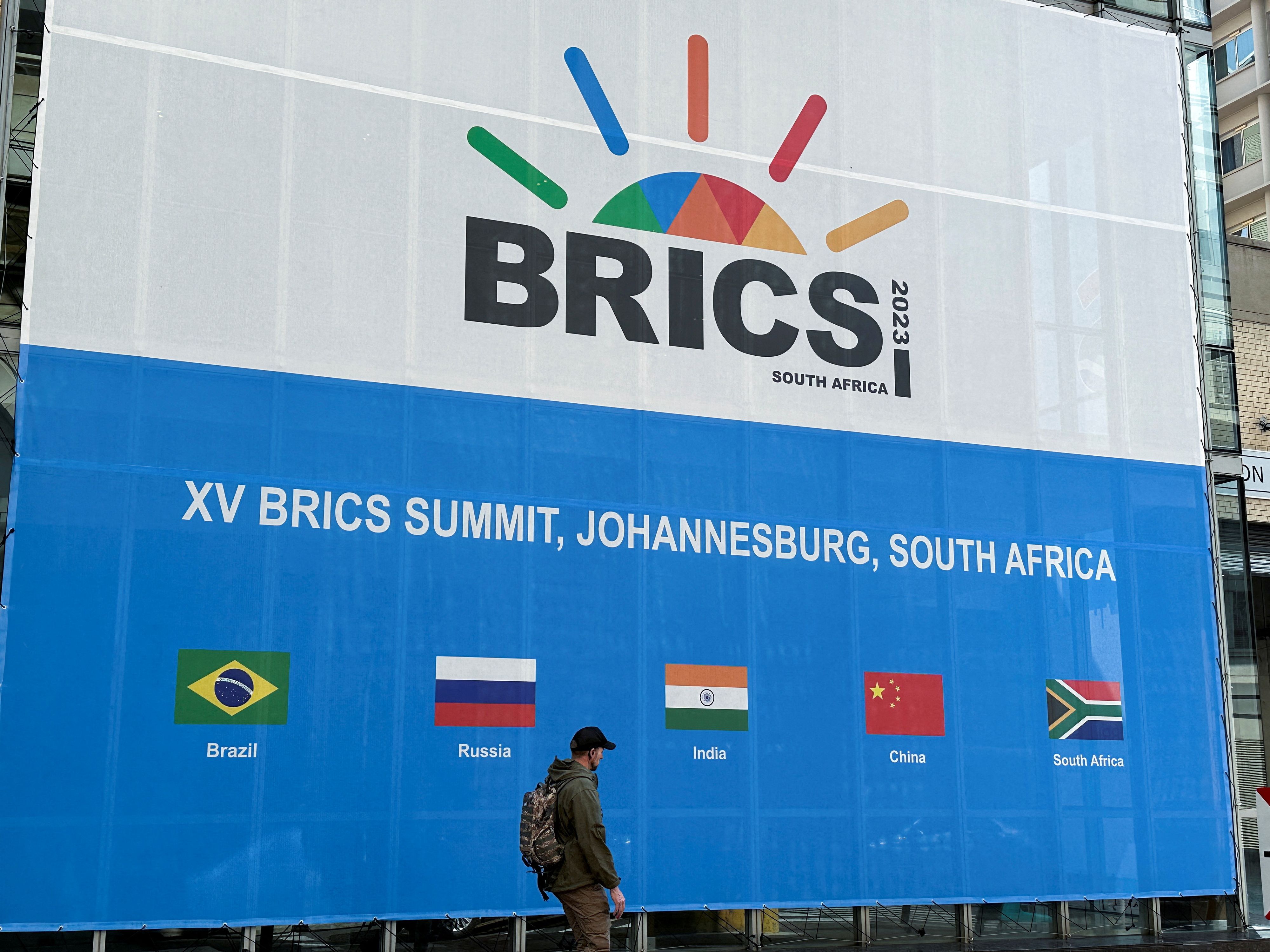 FILE PHOTO: A person walks past the Sandton Convention Centre, which will host the upcoming BRICS Summit, in Johannesburg, South Africa August 19, 2023. REUTERS/James Oatway/File Photo