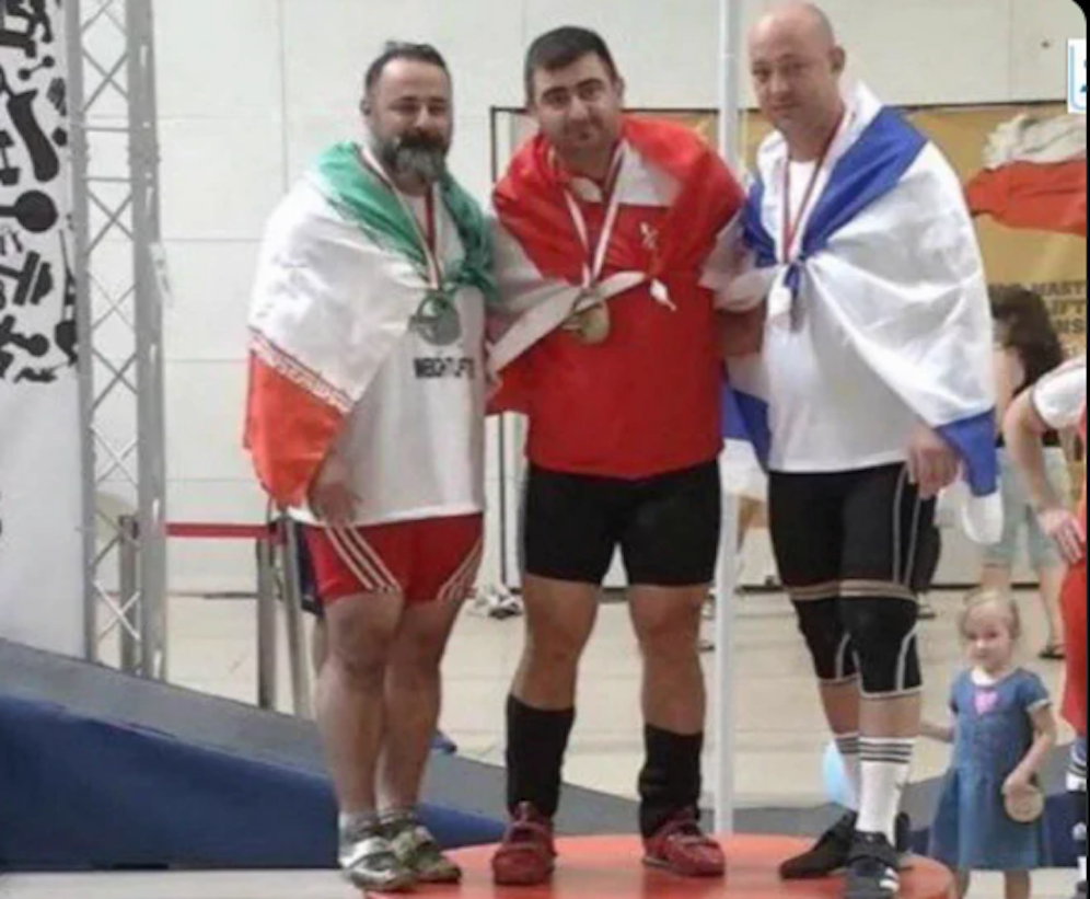 Links: Langrudi mit der Iran-Flagge. Rechts im Bild: die Israel-Fahne.