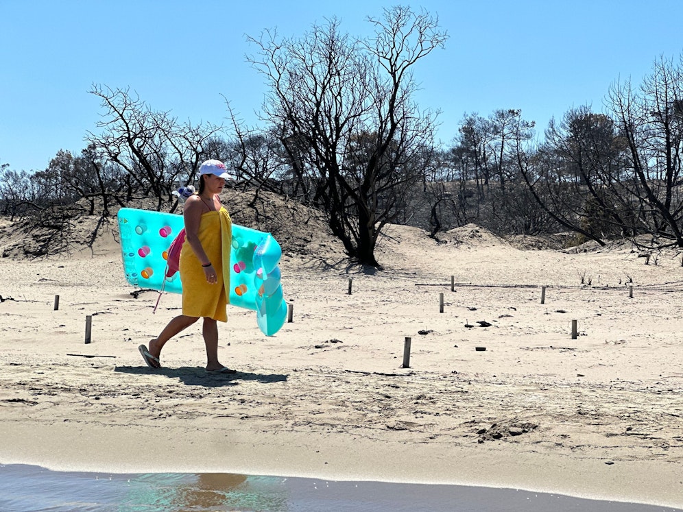 Badende auf einem von den schweren Bränden betroffenen Gebiet in der Nähe der Stadt Asklipio (Asklepieion) auf der griechischen Insel Rhodos.