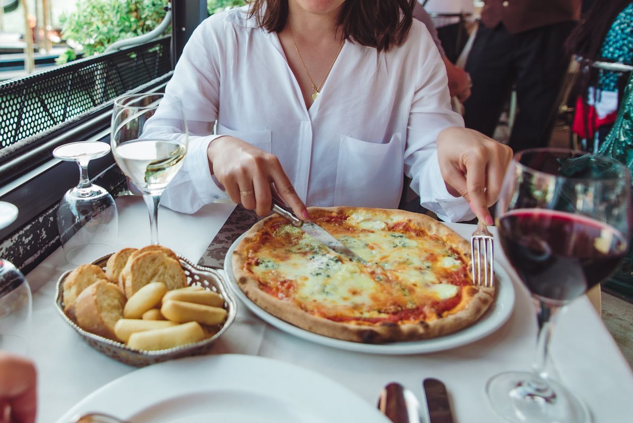 crop picture of woman in restaurant eating pizza drinking wine outdoors cafe