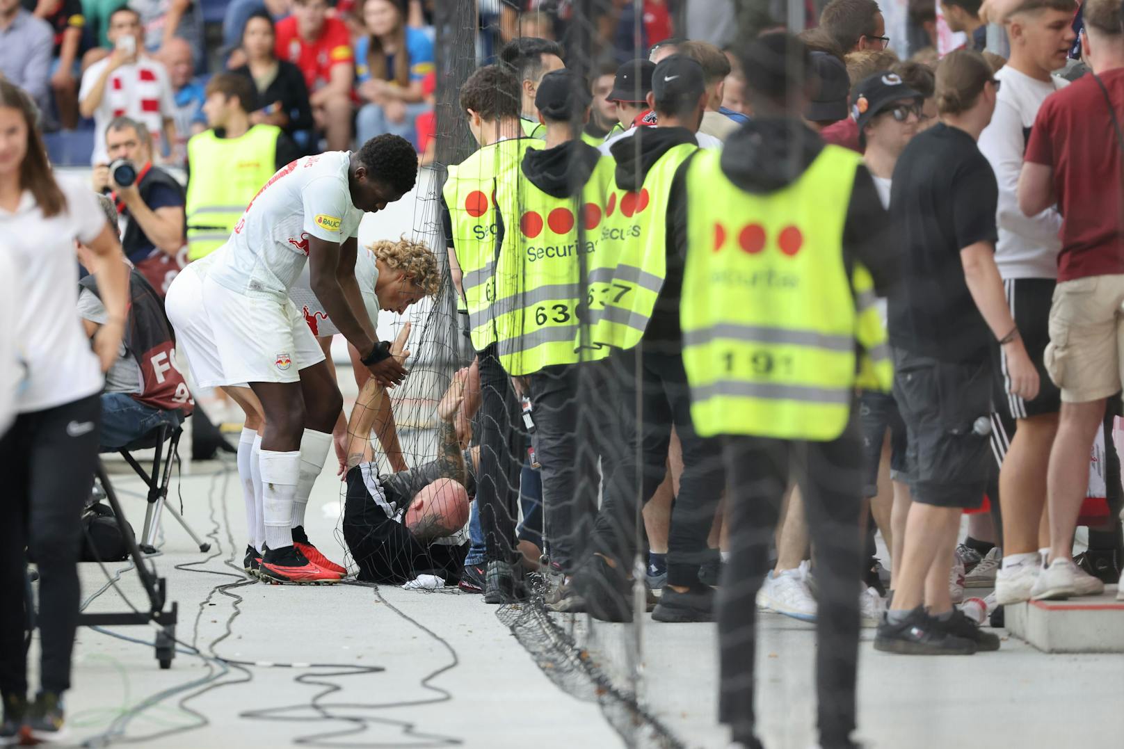 Salzburg-Spieler kümmern sich um einen am Boden liegenden Fan.&nbsp;