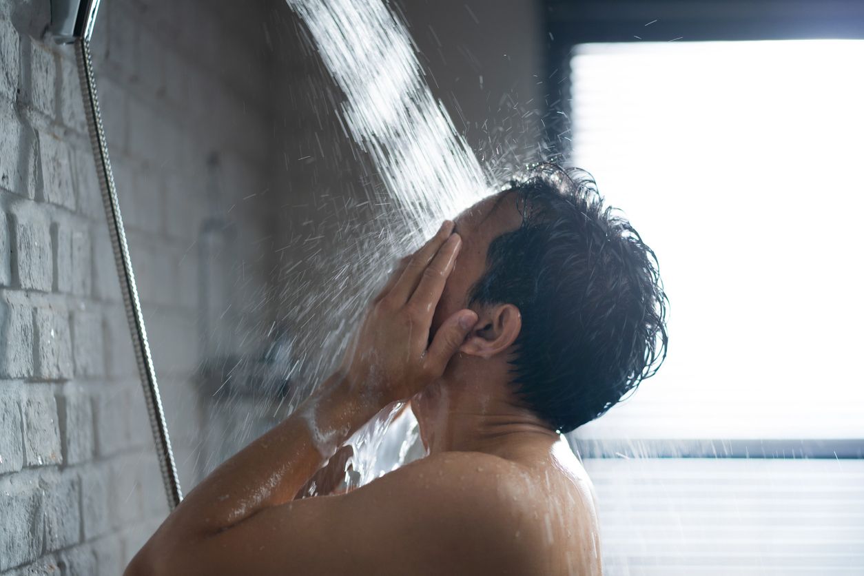 Handsome asian guy Taking a shower in the bathroom