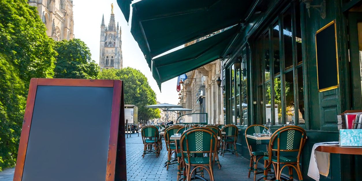  Cafe-Terrasse mit Tischen und Stühlen in Bordeaux, Frankreich (Symbolfoto)