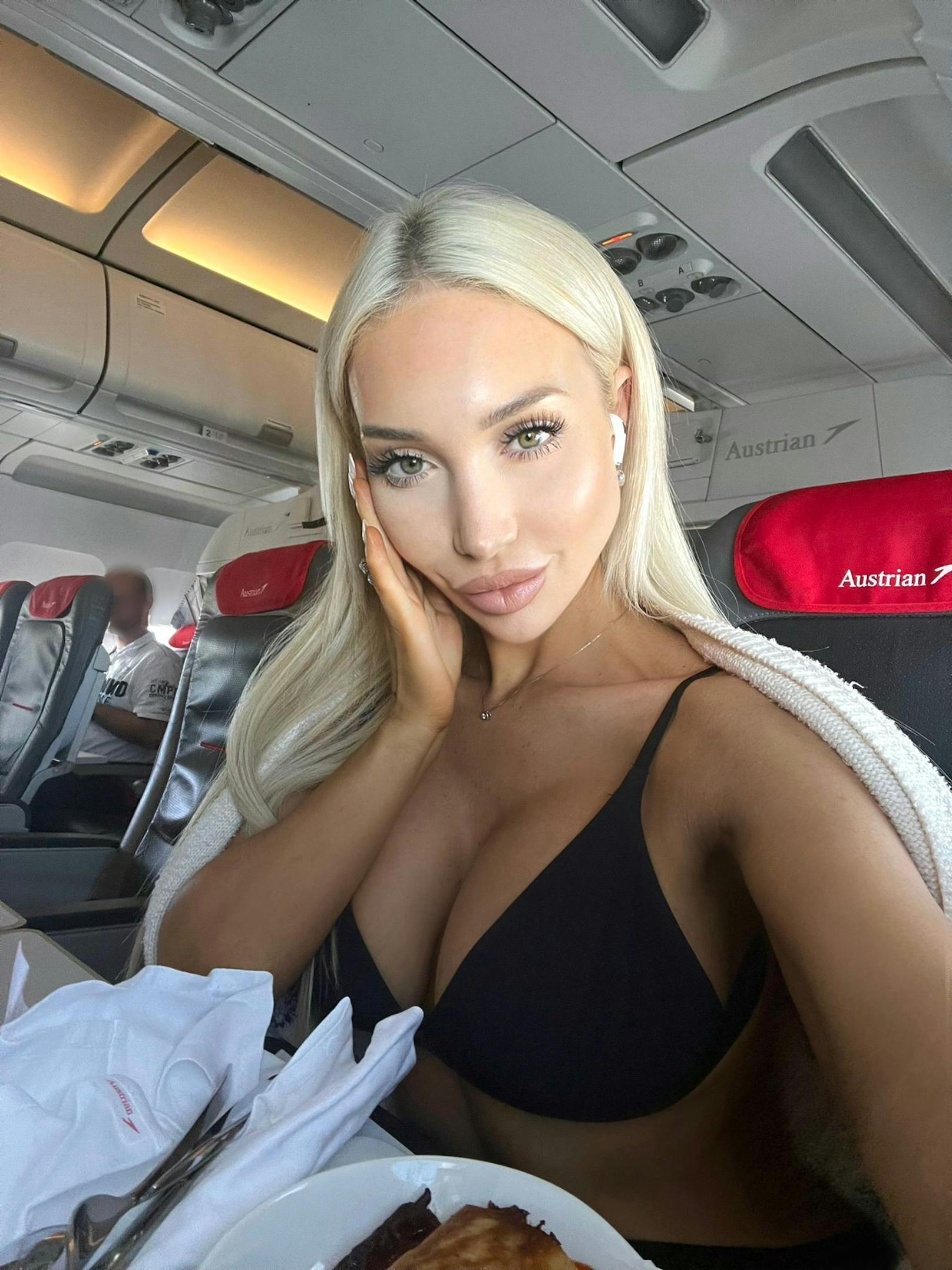 Das Wiener Playboy-Model Conny Hawk machte in der Business Class der Austrian Airlines ein paar heiße Aufnahmen von sich. Als sie die Fotos genauer unter die Lupe nahm, bemerkte sie einen Mann im Hintergrund, der heimlich Bilder von ihr machte.