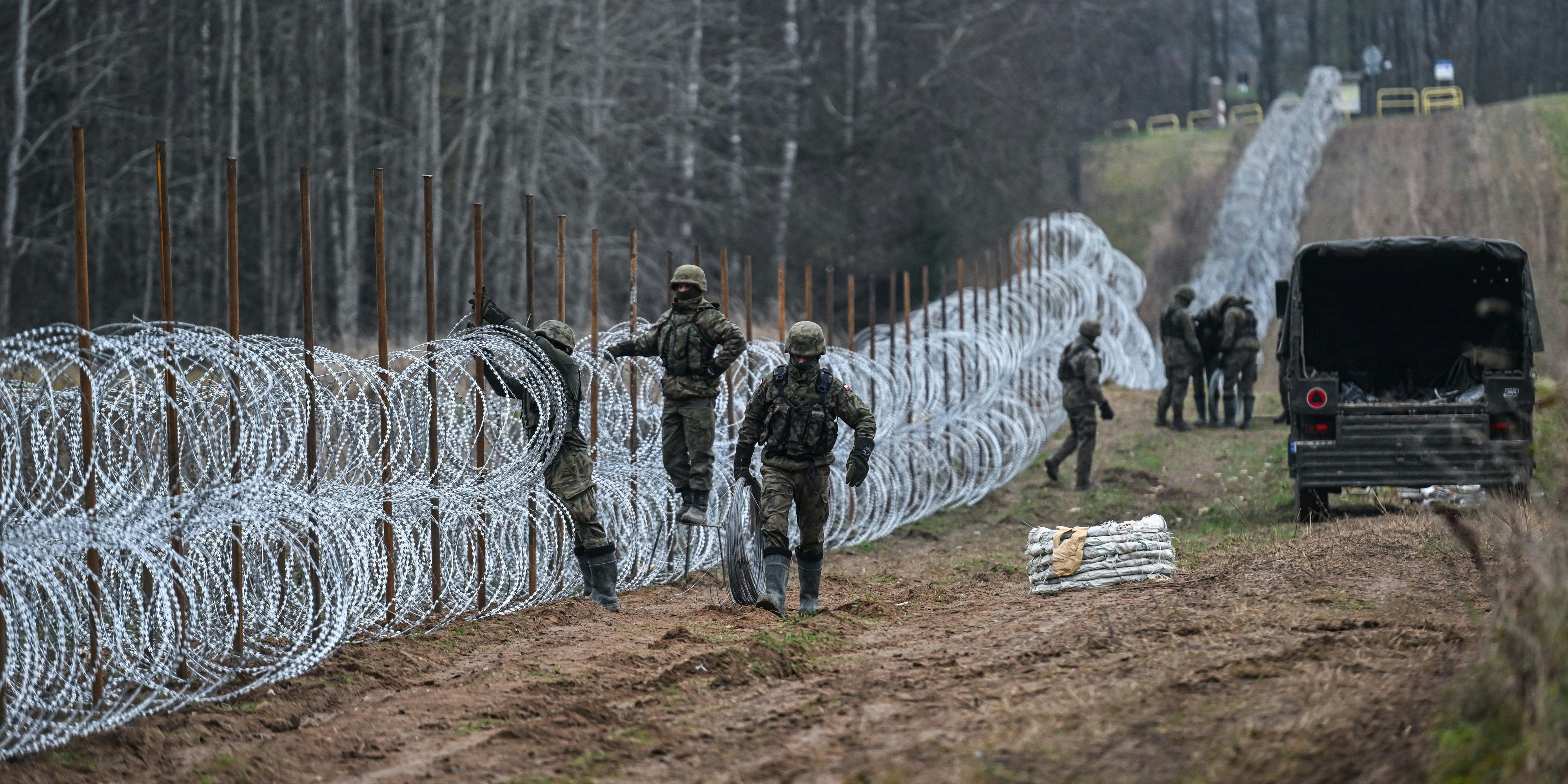 WISZTYNIEC, POLAND - NOVEMBER 05: Soldiers of the Polish army carry barbed wire as they construct a barrier on Poland's- Russian exclave Kaliningrad border on November 05, 2022 in Wisztyniec, Poland. From October 1st, Russia's Federal Air Transport Agency and the chief executive of the Khrabrovo airport in Kaliningrad, Alexander Korytnyi announced the "open sky" mode, allowing foreign airlines to operate flights to/from Kaliningrad using the third, fourth,fifth and seventh freedoms of airspace. Some of the airlines, from the Middle East, have been invited to operate, bringing fears that a new migration route will be open, like what happened last year at Poland's border with Belarus, when thousands of people from the Middle East and Africa stormed the Polish Belarussian border after a similar open sky policy was prepared by Aleksandr Lukashenko. Omar Marques / Anadolu Agency (Photo by Omar Marques / ANADOLU AGENCY / Anadolu Agency via AFP)