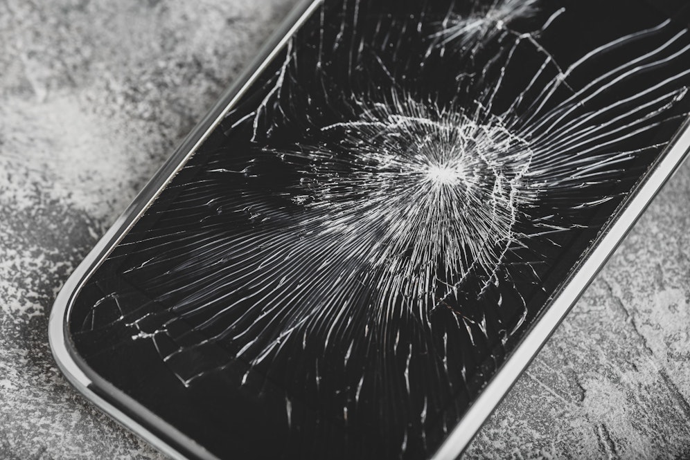 Ein Smartphone fällt auf die Straße und löst automatisch einen Notruf aus. (Symbolbild)