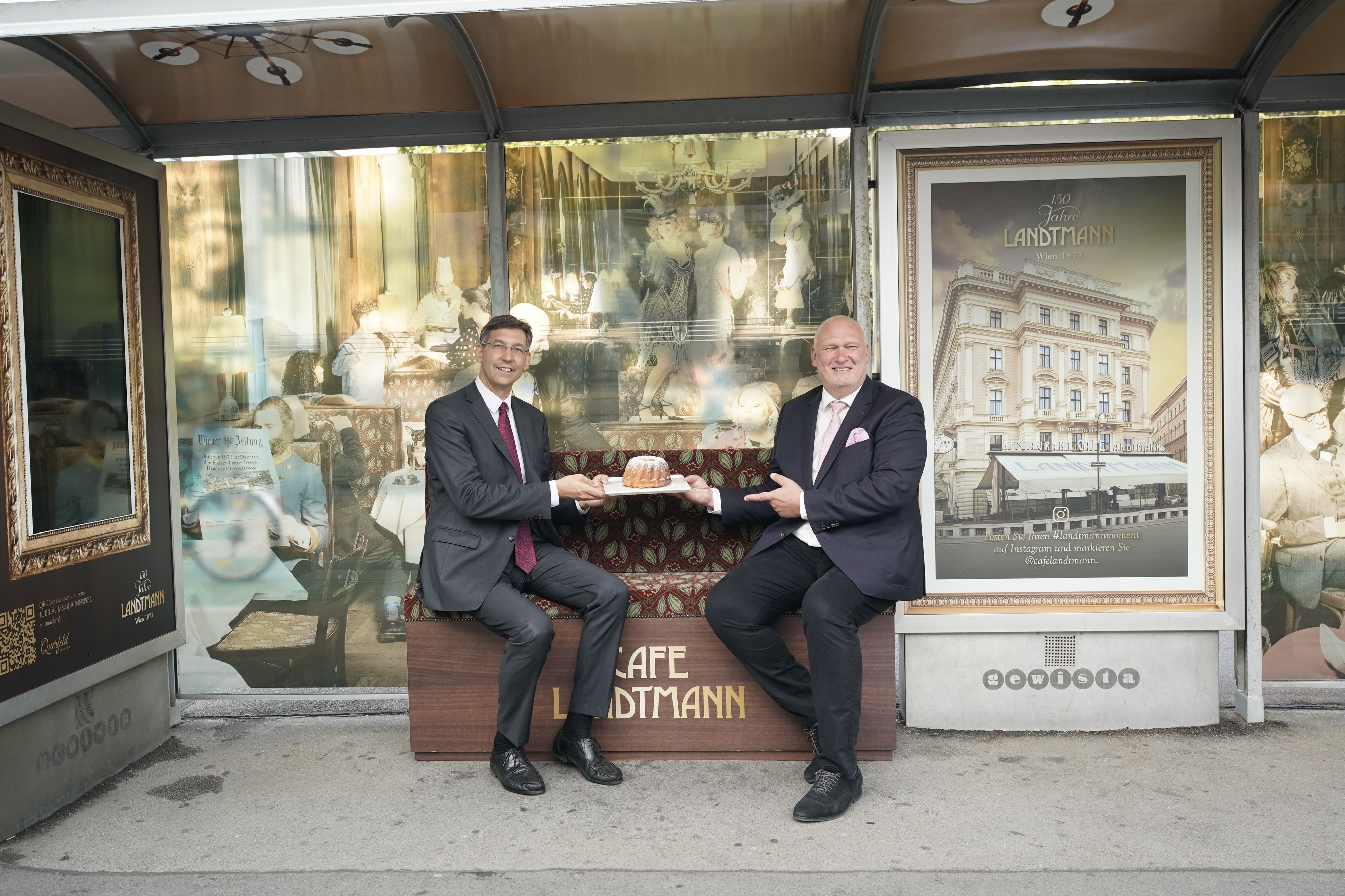 Bezirksvorsteher Markus Figl und Landtmann-Geschäftsführer Berndt Querfeld warten mit Guglhupf auf die nächste Bim.