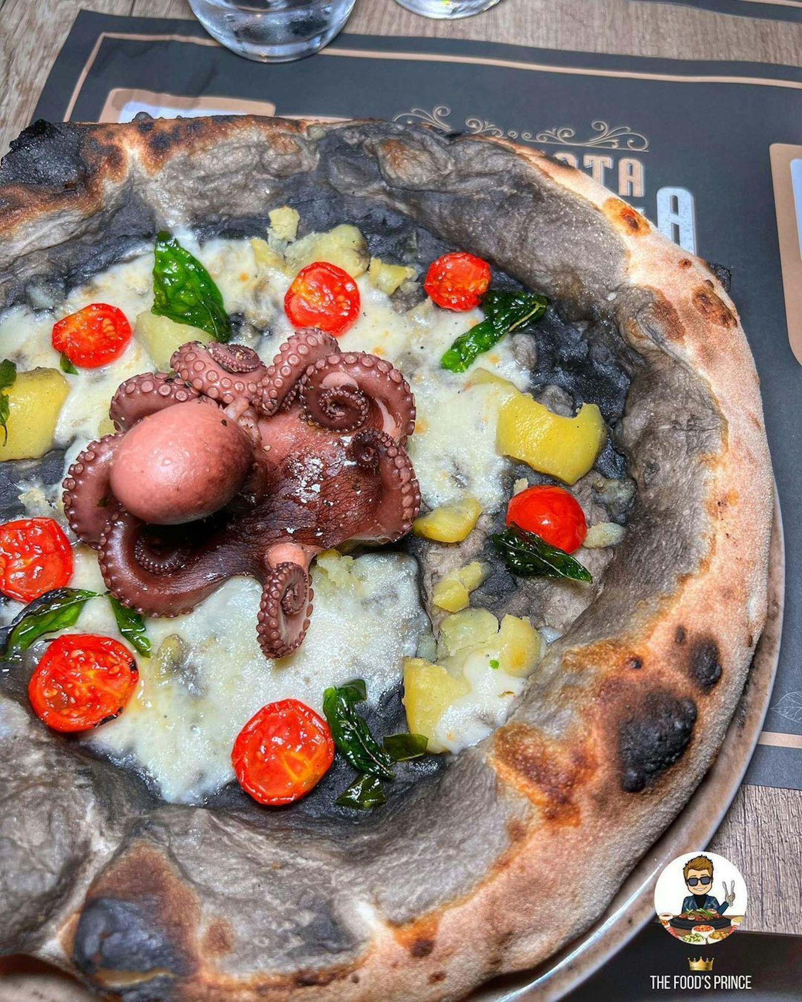 So sieht die Pizza mit flaumigem&nbsp;<a data-li-document-ref="40572596" href="https://www.heute.at/s/neapolitanische-pizza-ist-jetzt-unesco-kulturerbe-40572596">neapolitanische</a>n&nbsp;Teig, schwarzer Tintenfisch-Creme, Petersilienkartoffeln, Cocktailtomaten und kristallisiertem Basilikum vor den Flammen aus.