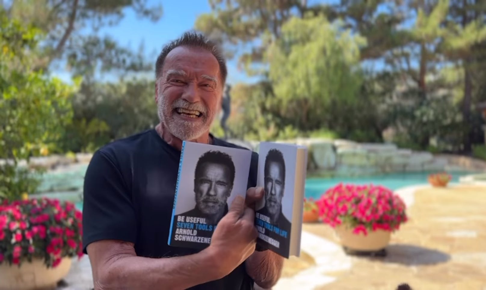 Stolz hält Arnie sein Werk "Be Useful - Sieben einfache Regeln für ein besseres Leben" in den Händen.