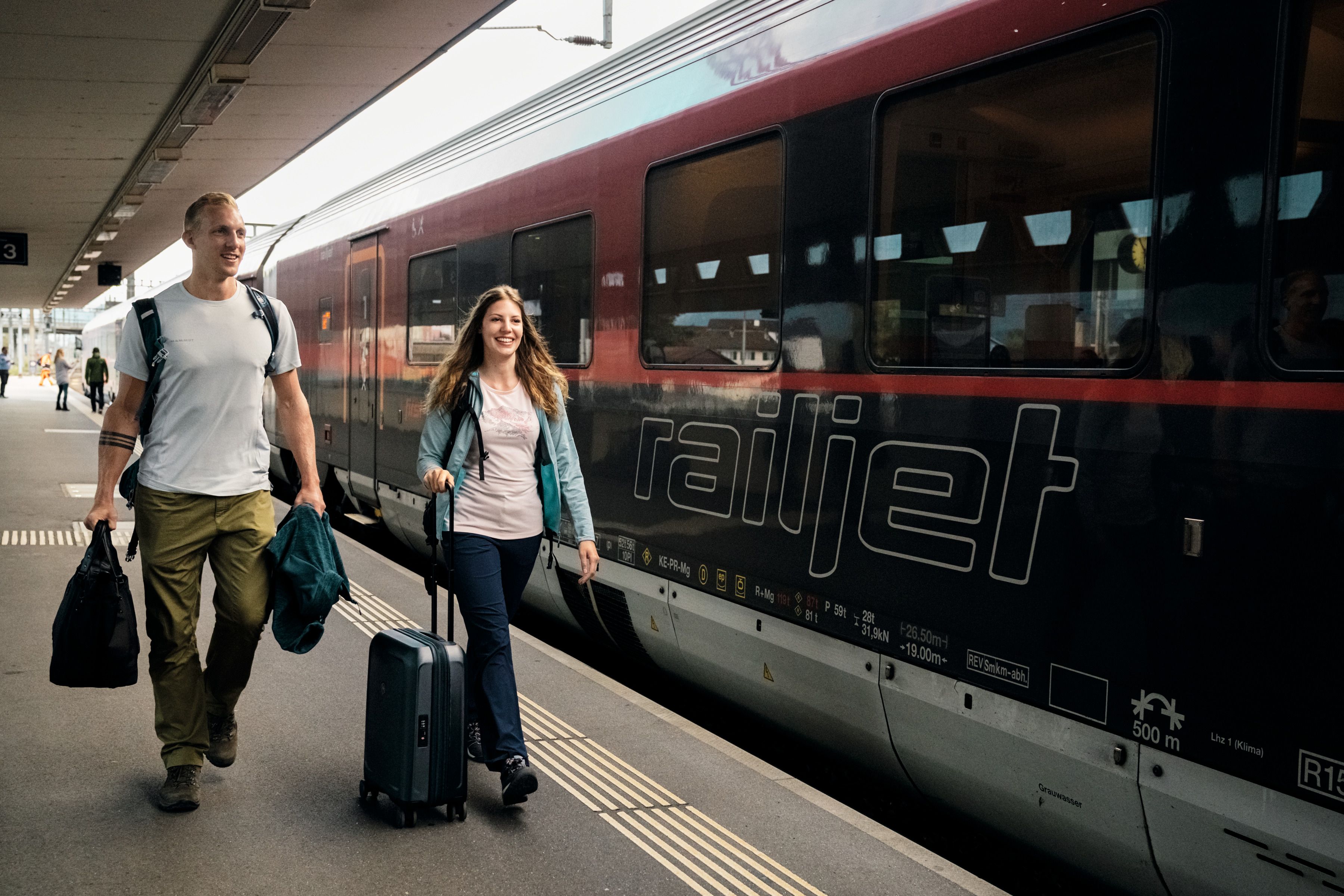 Download von www.picturedesk.com am 05.10.2023 (15:29).  BILD zu OTS - Bahnreisepaar vor dem ÖBB Railjet am Bahnhof Buchs. *** Die Nutzung des Bildes für redaktionelle Zwecke ist kostenlos. Weitergehende Nutzung bedarf der Zustimmung des Aussenders. *** - 20220629_PD5743 - Rechteinfo: OTS-Bild (OTS) Redaktionelle Nutzung im thematischen Zusammenhang mit der Aussendung kostenfrei gestattet.