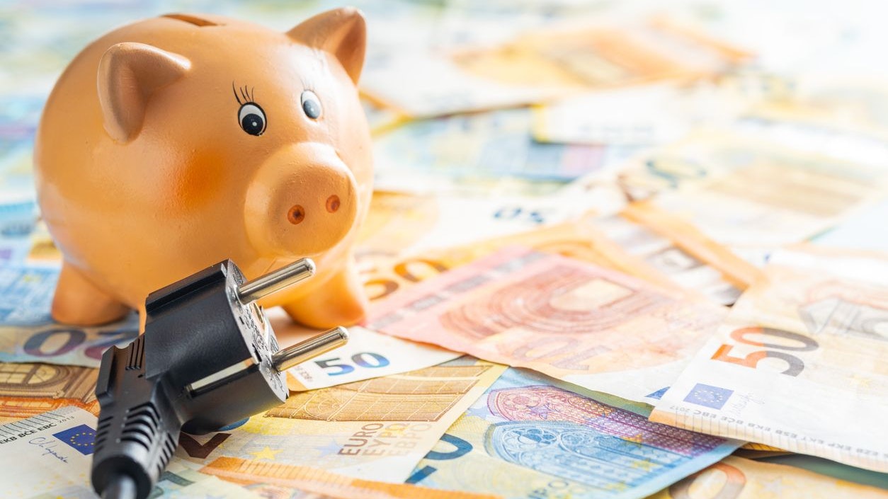 Electric plug, piggy bank and euro money. Concept of the increasing electricity prices.