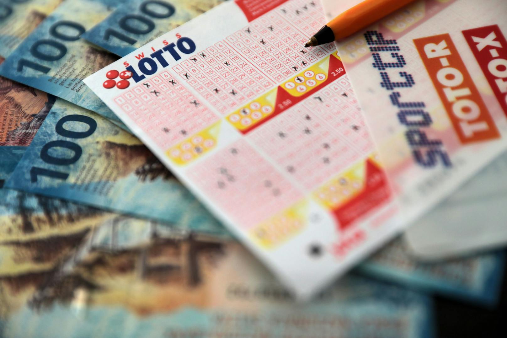 Ein Schweizer Lottoschein mit Franken-Banknoten. Archivbild.