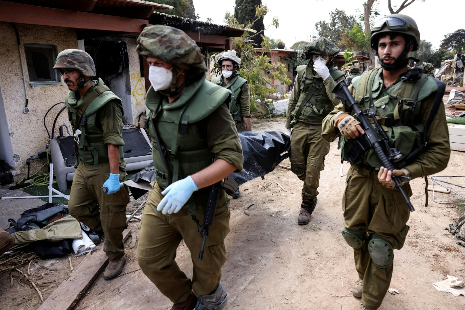 Die israelischen Truppen gehen von Haus zu Haus, um die Leichen von Zivilisten in Leichensäcken zu bergen. 