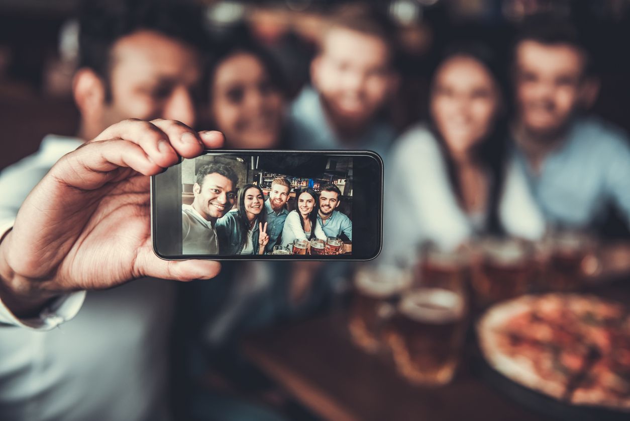 Selfie time! Handsome friends making selfie and smiling while resting at pub.