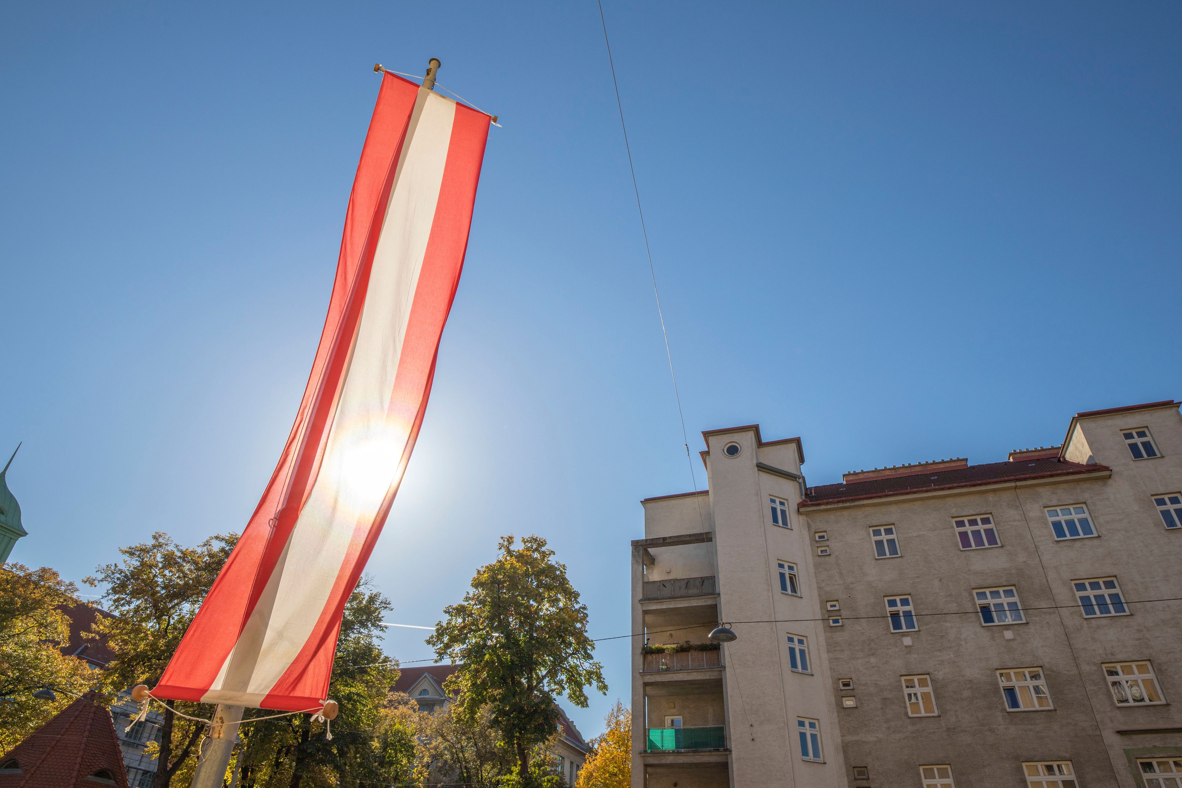 Die Sonne scheint durch eine Österreich-Fahne Ende Oktober. (Archivbild)