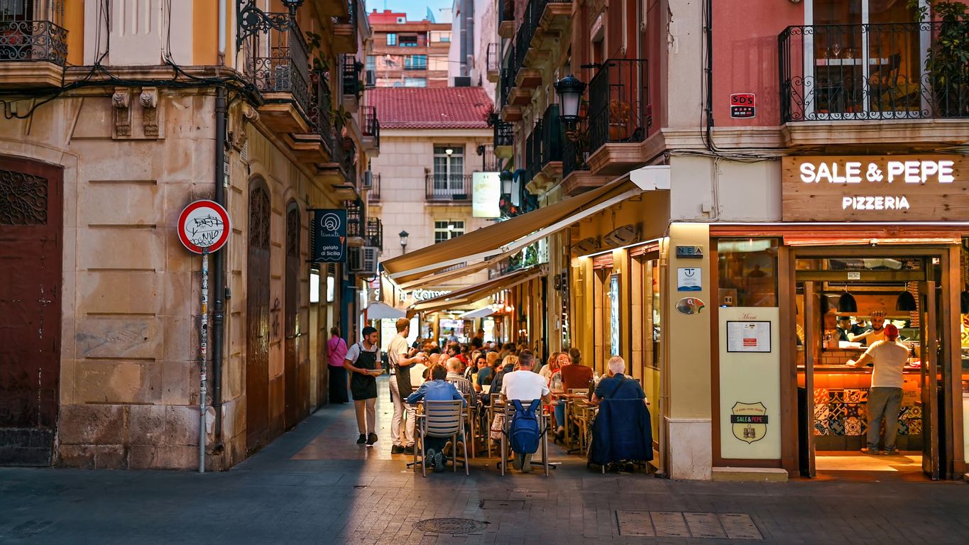 alicante, spain - april 26 2023: people sitting and talking in a cafe on a street