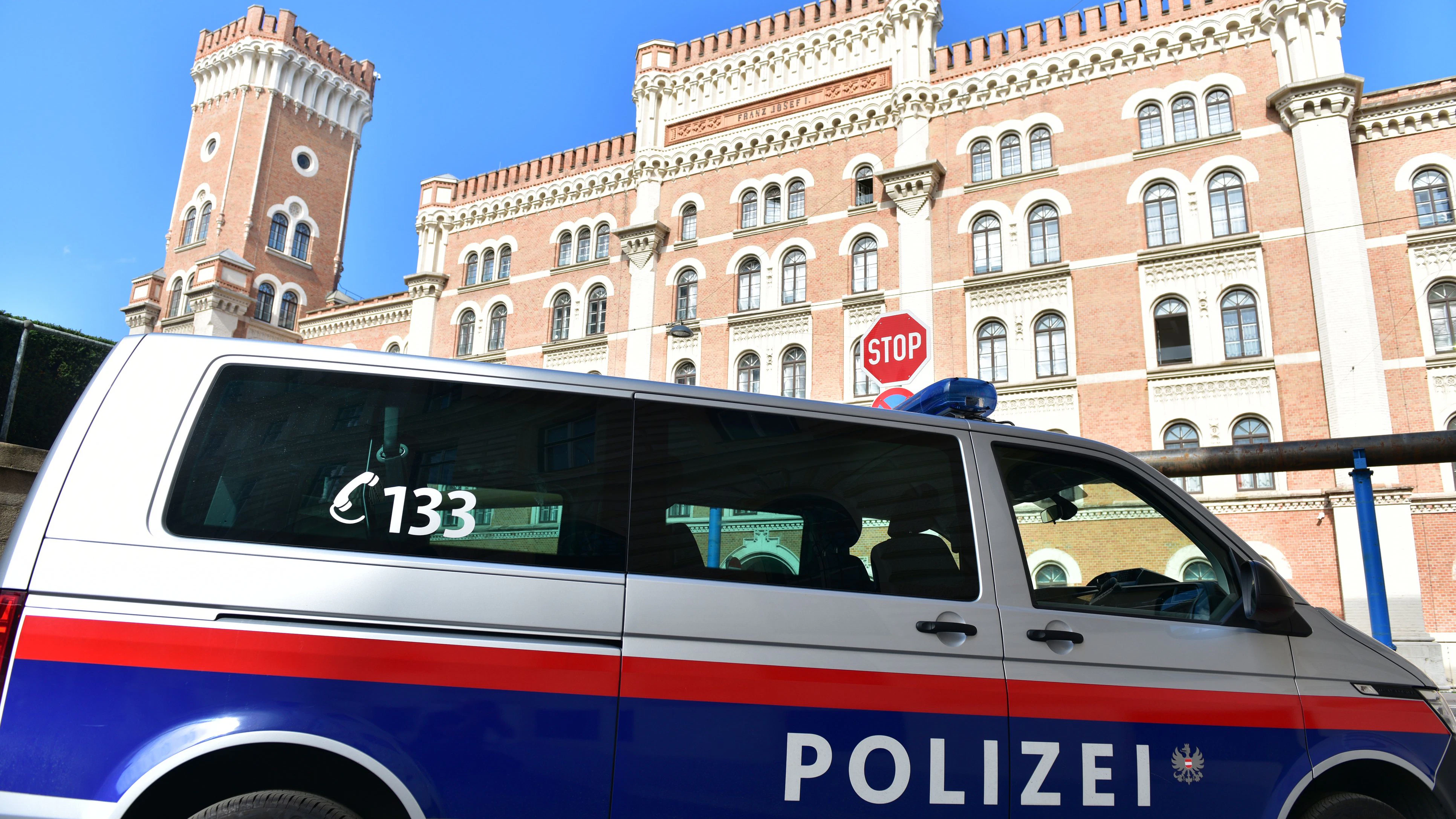 Police car in front of the well-known Rossauer Kaserne in Vienna, headquarters of the Austrian Federal Ministry of Defense, in the summer with blue sky
