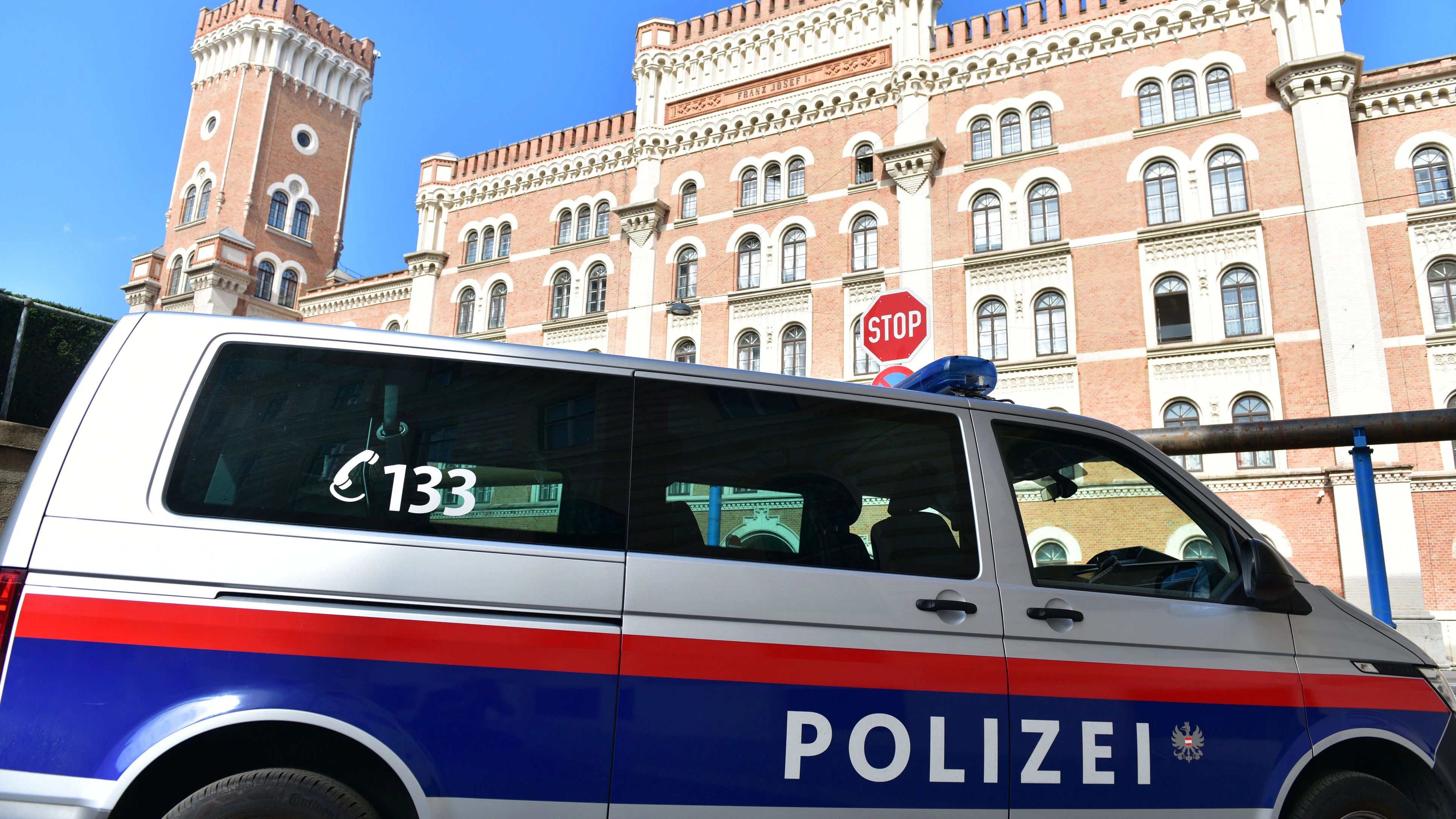 Police car in front of the well-known Rossauer Kaserne in Vienna, headquarters of the Austrian Federal Ministry of Defense, in the summer with blue sky