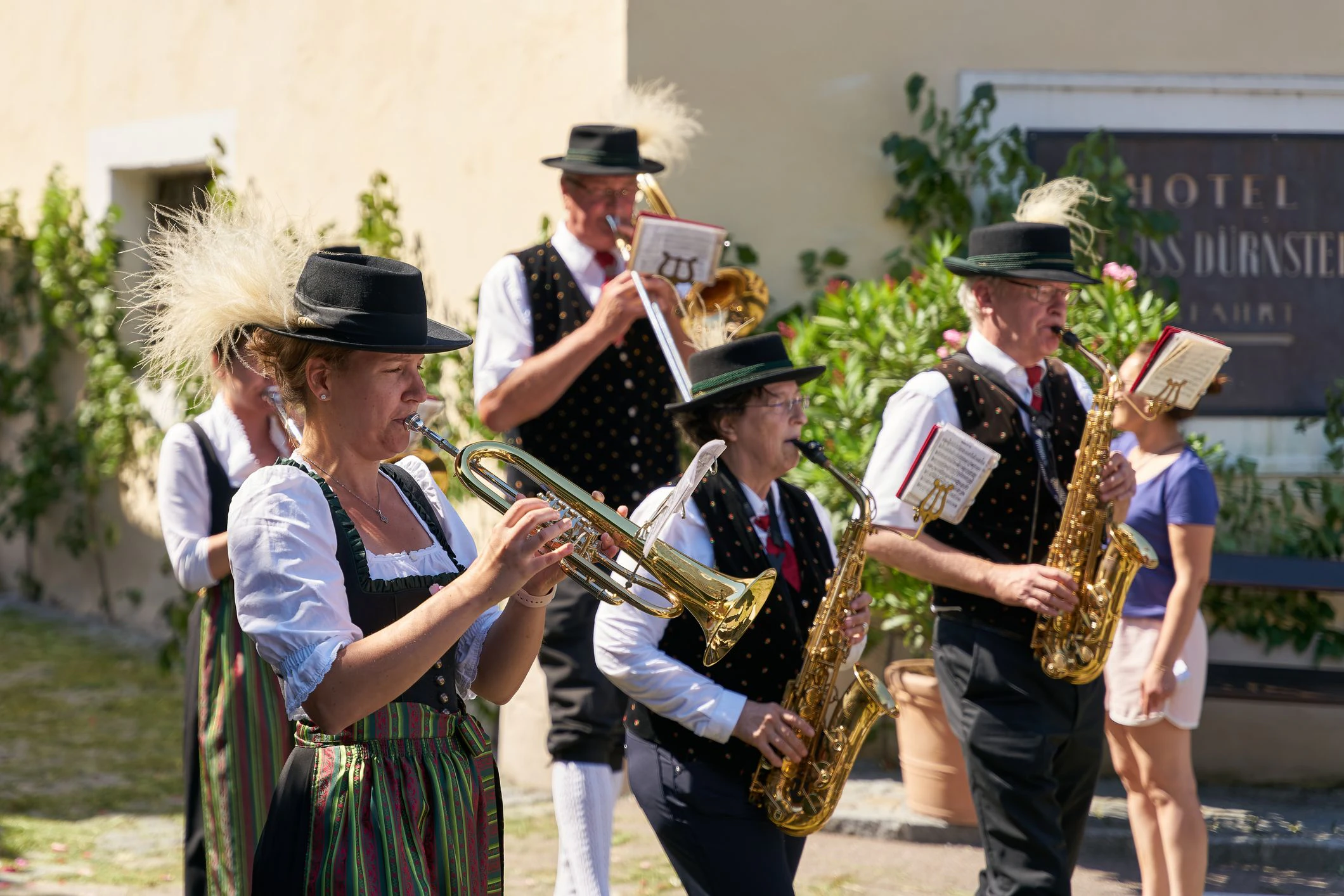 Duernstein, Austria – June 16, 2022: Members of the brass band Dürnstein in traditional costumes during a procession on Corpus Christi in front of the castle in Dürnstein
