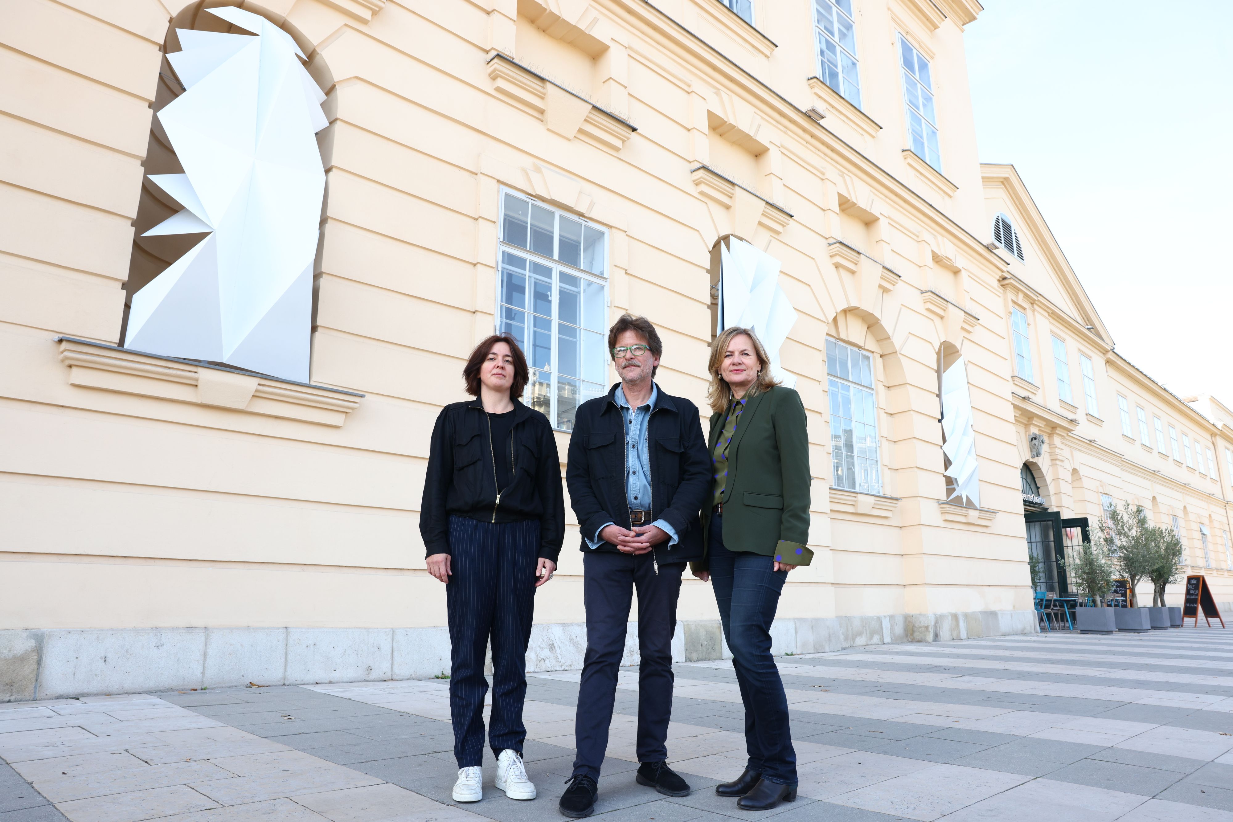 Die beiden Künstler Sonia Leimer und Tillman Kaiser mit MQ-Direktorin Bettina Leidl (v.l.) vor der neu gestalteten Fassade des MQ. 