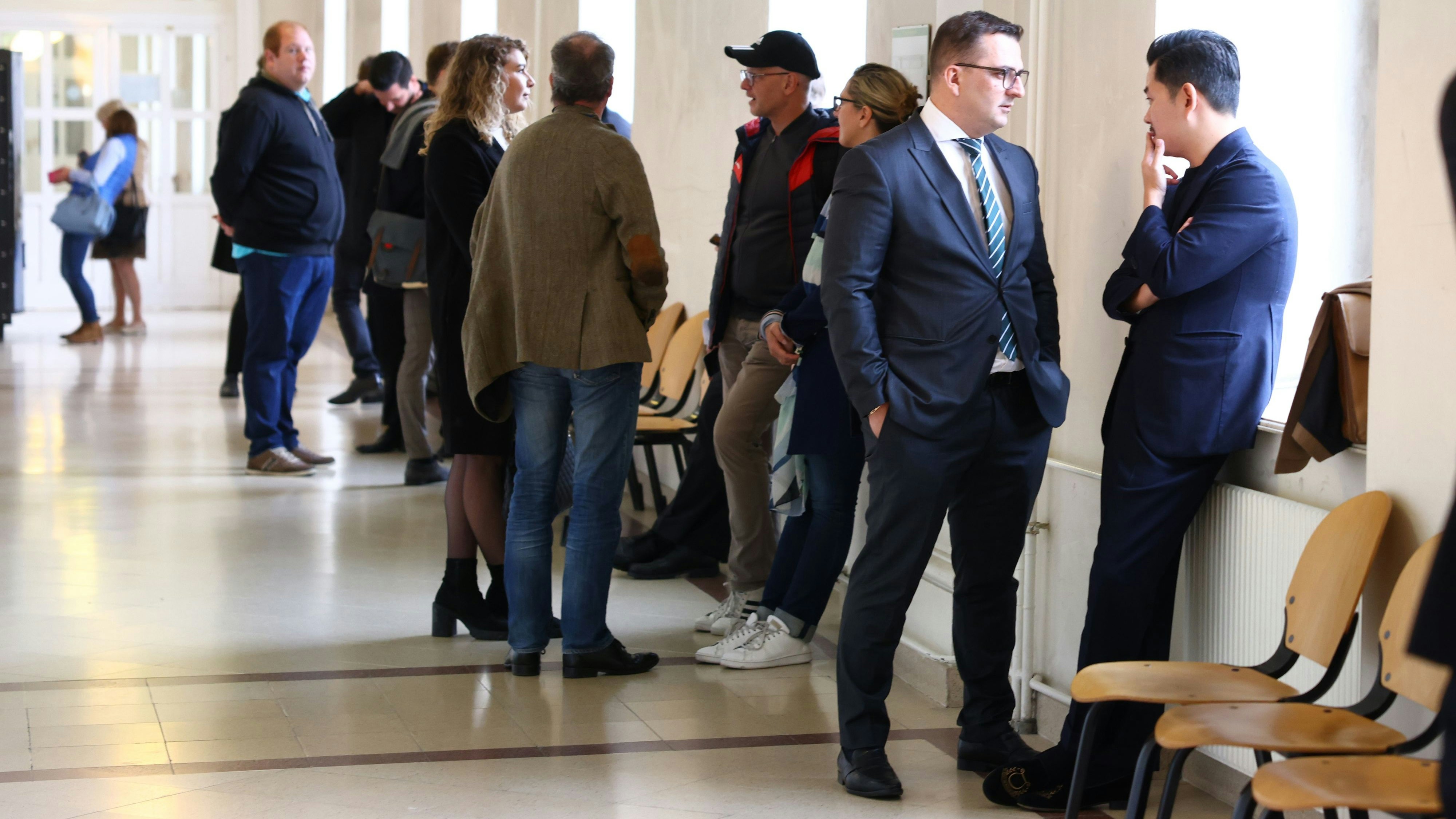 Wartende vor dem Prozess in Wien, darunter Martin Ho (r.) mit Anwalt.