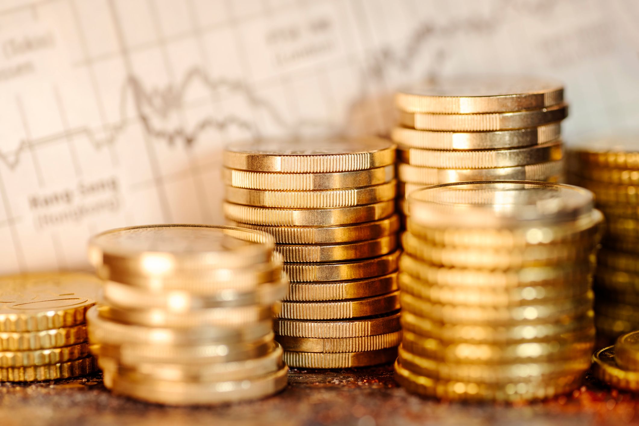 Several stacks of coins and chart with stock market prices. High profits on the international stock exchanges