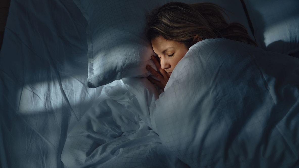 High angle view of a woman taking a nap in her bed at night. Photographed in medium format.