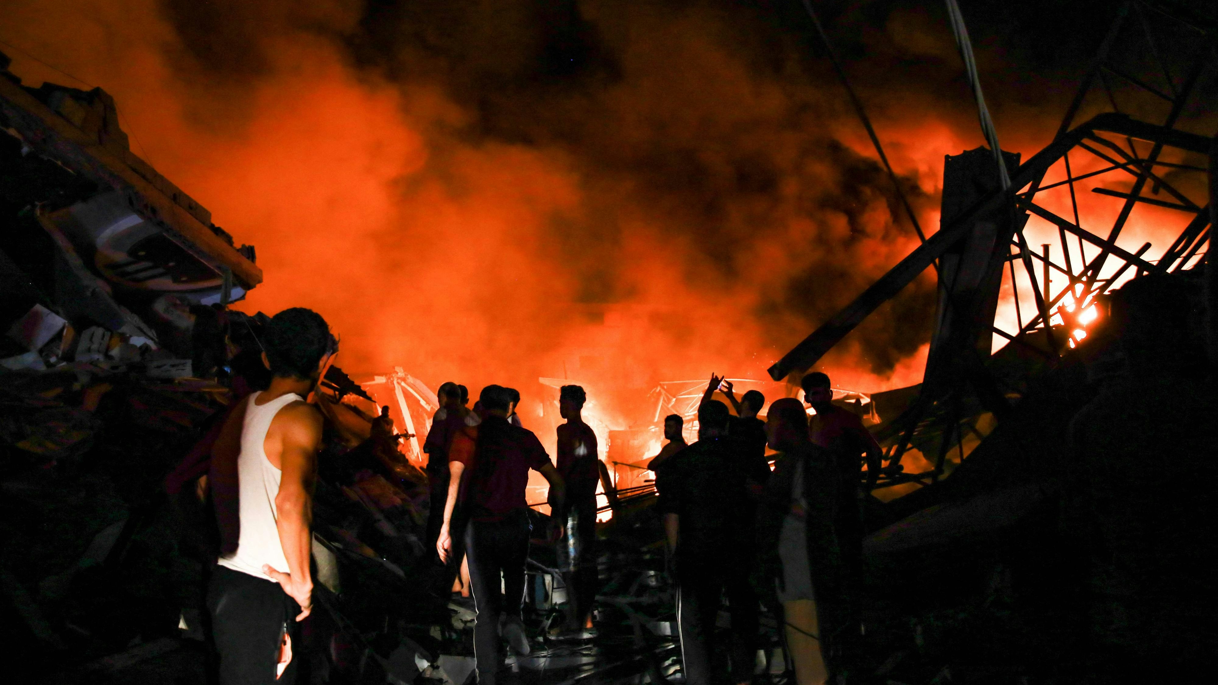Download von www.picturedesk.com am 27.10.2023 (10:24).  Smoke and fire rise from buildings as people gather amid the destruction in the aftermath of an Israeli strike on Gaza City on October 26, 2023, as battles continue between Israel and the Palestinian Hamas group. (Photo by Omar El-Qattaa / AFP) - 20231026_PD9205 - Rechteinfo: Rights Managed (RM) Nur für redaktionelle Nutzung! Werbliche Nutzung erfordert Freigabe: bitte schicken Sie uns eine Anfrage.