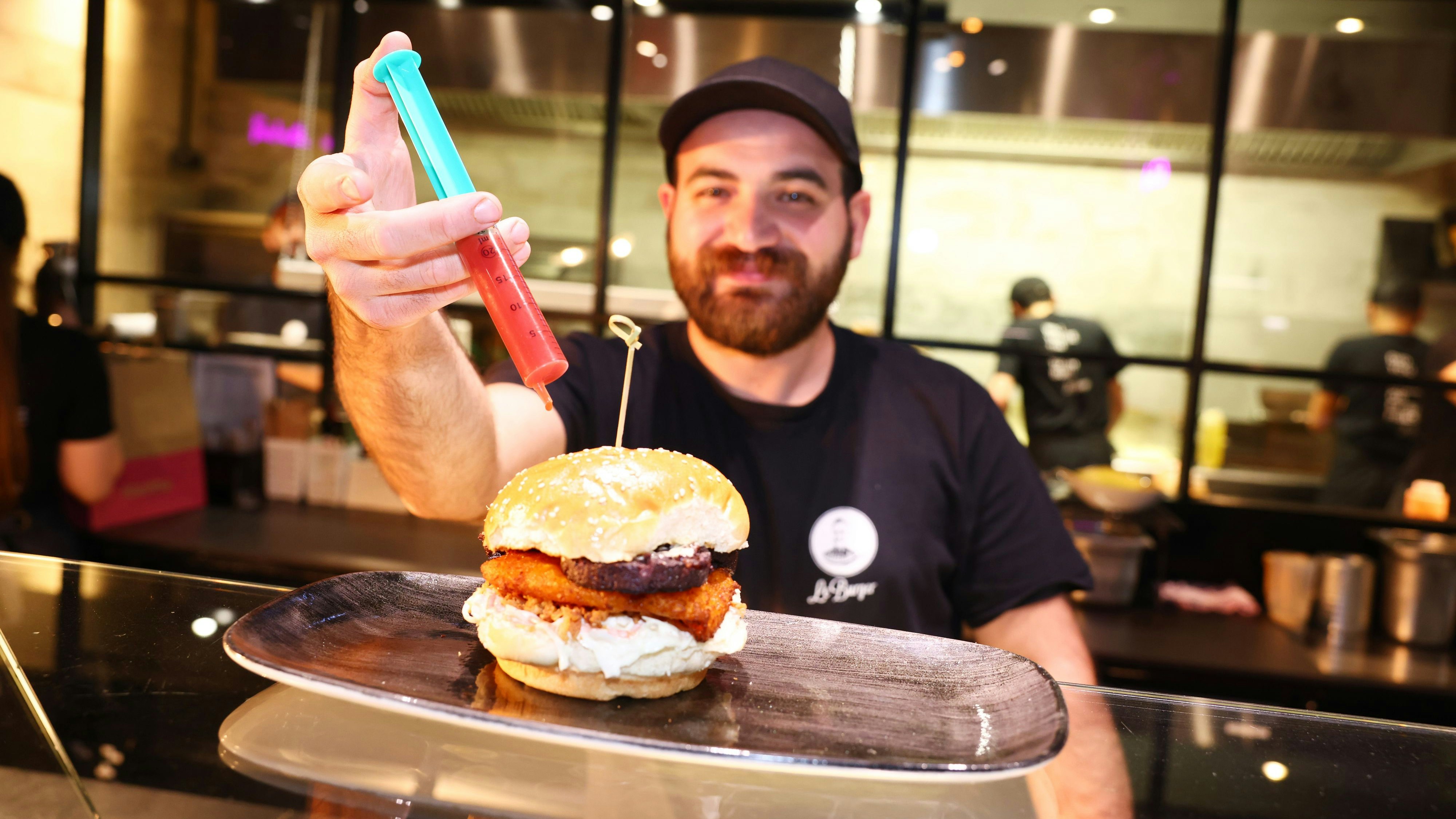 Mit gegrillter Blutwurst, Kürbis, Röstzwiebel, Coleslaw und Erdbeer-Ketchup aus der Spritze will der "Trick or Treat"-Burger überzeugen.