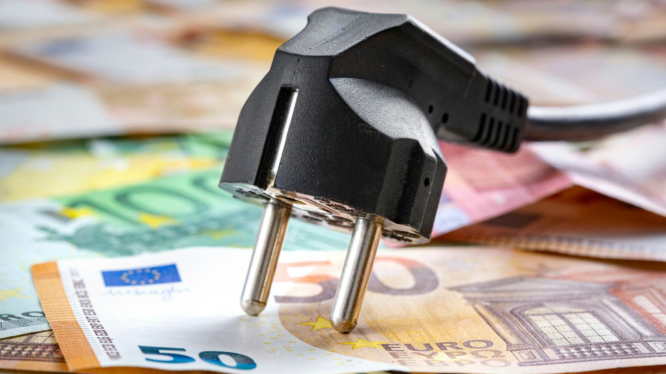 Black power plug and money - concept of cost of energy