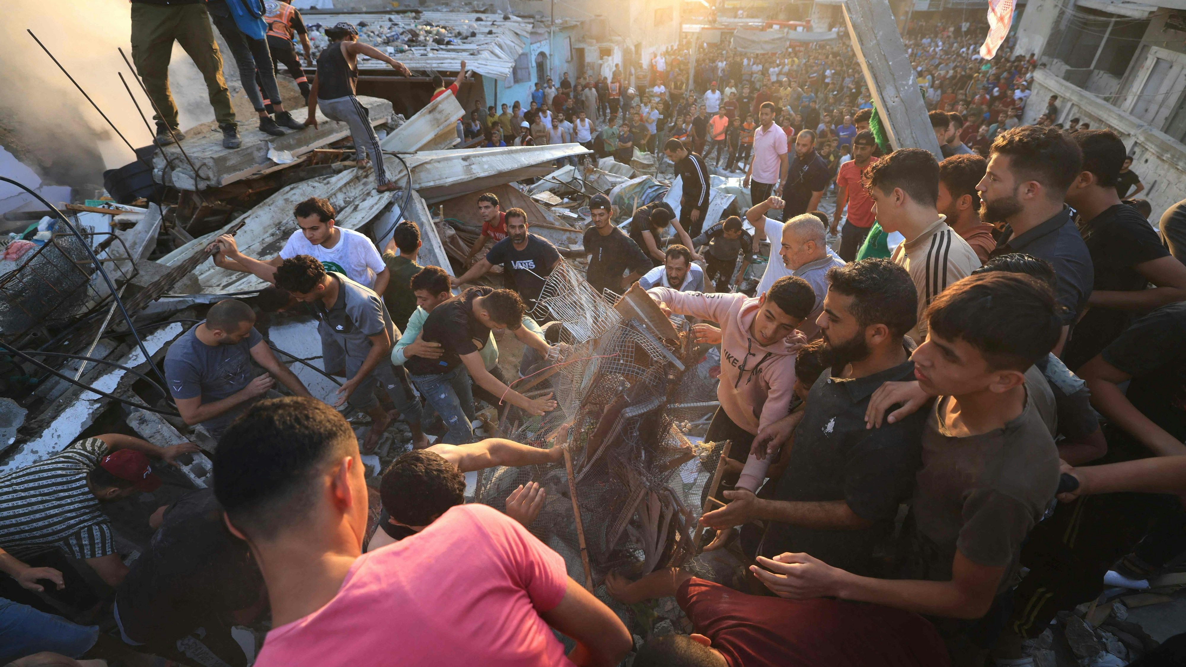 Download von www.picturedesk.com am 04.11.2023 (08:04).  Palestinian stand on the rubble of a collapsed building looking for survivors and victims following a strike by the Israeli military on Khan Yunis in the southern Gaza Strip on November 4 , 2023, amid the ongoing battles between Israel and the Palestinian group Hamas. Thousands of civilians, both Palestinians and Israelis, have died since October 7, 2023, after Palestinian Hamas militants based in the Gaza Strip entered southern Israel in an unprecedented attack triggering a war declared by Israel on Hamas with retaliatory bombings on Gaza. (Photo by Mahmud HAMS / AFP) - 20231104_PD0992 - Rechteinfo: Rights Managed (RM) Nur für redaktionelle Nutzung! Werbliche Nutzung erfordert Freigabe: bitte schicken Sie uns eine Anfrage.